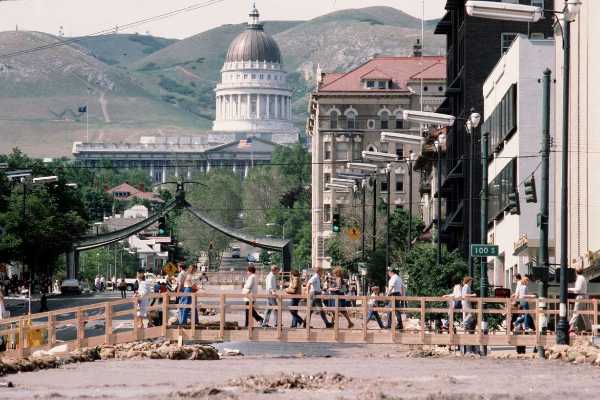 Pedestrians cross the State Street river of water during the floods of 1983 in Salt Lake City. (Photo: Ravell Call)