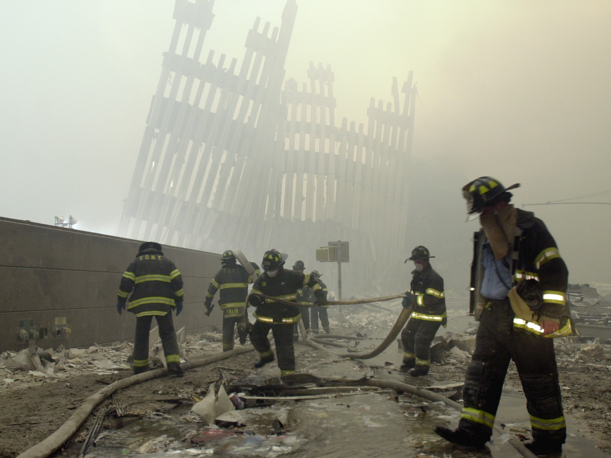 In this Sept. 11, 2001 file photo, firefighters work beneath the destroyed mullions, the vertical struts which once faced the soaring outer walls of the World Trade Center towers, after a terrorist attack on the twin towers in New York. (Mark Lennihan, AP Photo)