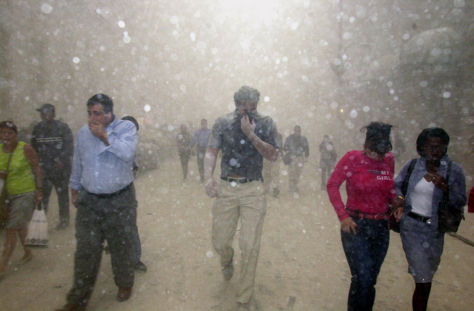 People run from the collapse of World Trade Center towers in New York, Tuesday, Sept. 11, 2001 after terrorists crashed two hijacked airliners into the World Trade Center and brought down the twin 110-story towers. (Suzanne Plunkett, AP Photo)