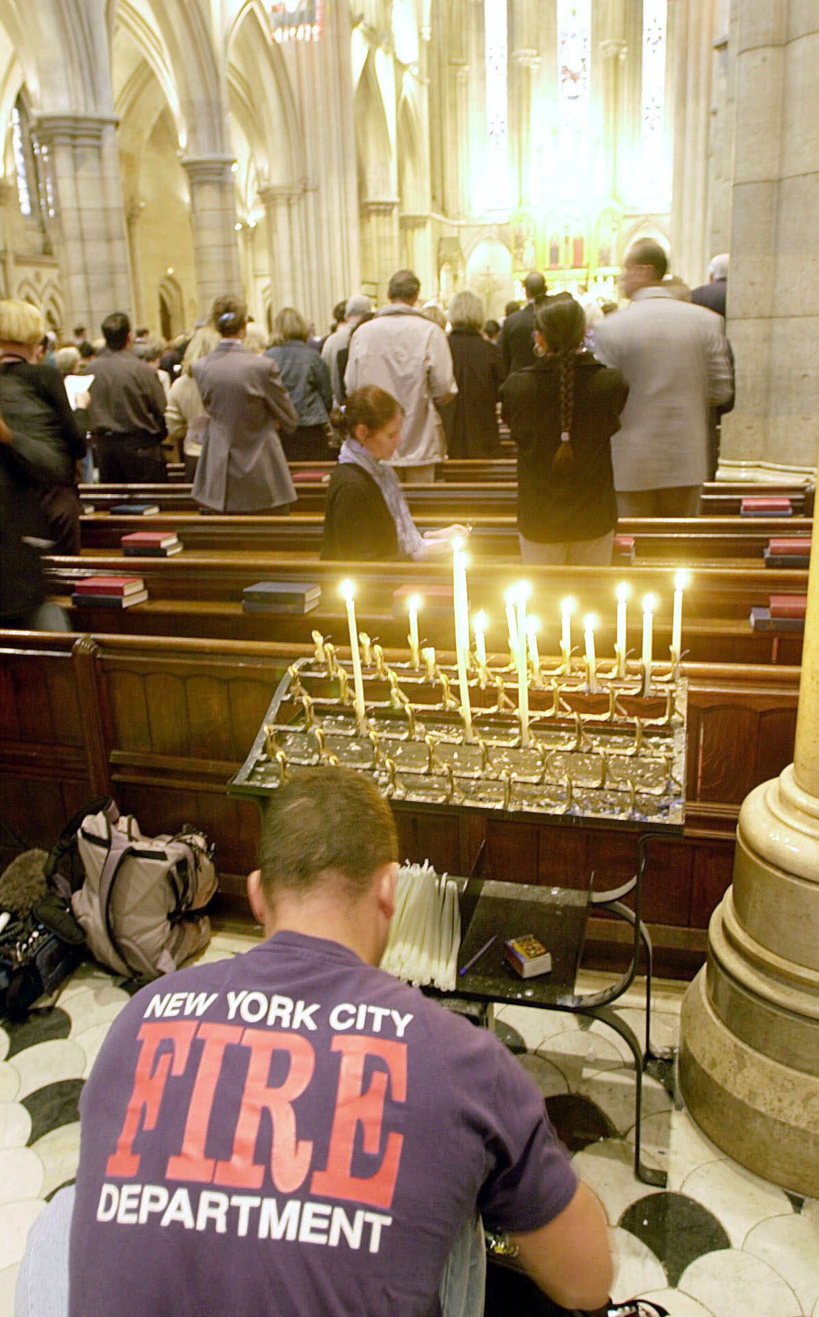 French firefighter Willy Proto, who trained at the New York fire brigade, prays at candles during a memorial service at the American Cathedral of Paris Wednesday Sept. 12, 2001, a day after the terrorist attacks on the United States. (Francois Mori, AP Photo)