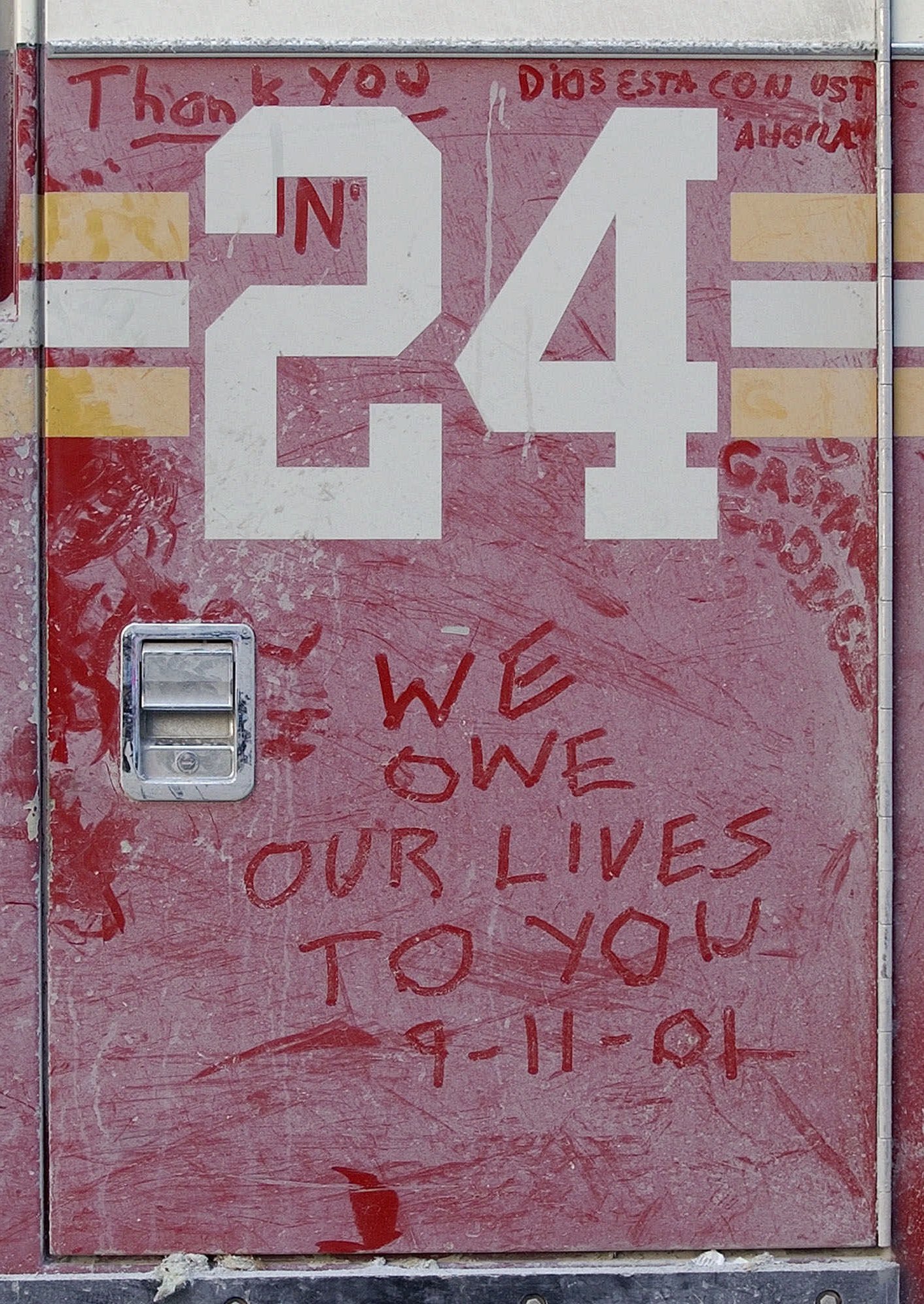 Messages scrawled in debris dust on the ladder truck door of Ladder Company 24 join a growing memorial on Wednesday, Sept. 12, 2001 in New York City to the firefighers from the company who lost their lives in the suspected terrorist attack on the World Trade Center. Ladder Company 24 lost 7 firemen in the attack, including Fire Chaplain Father Mychal Judge. (Amy Sancetta, AP Photo)