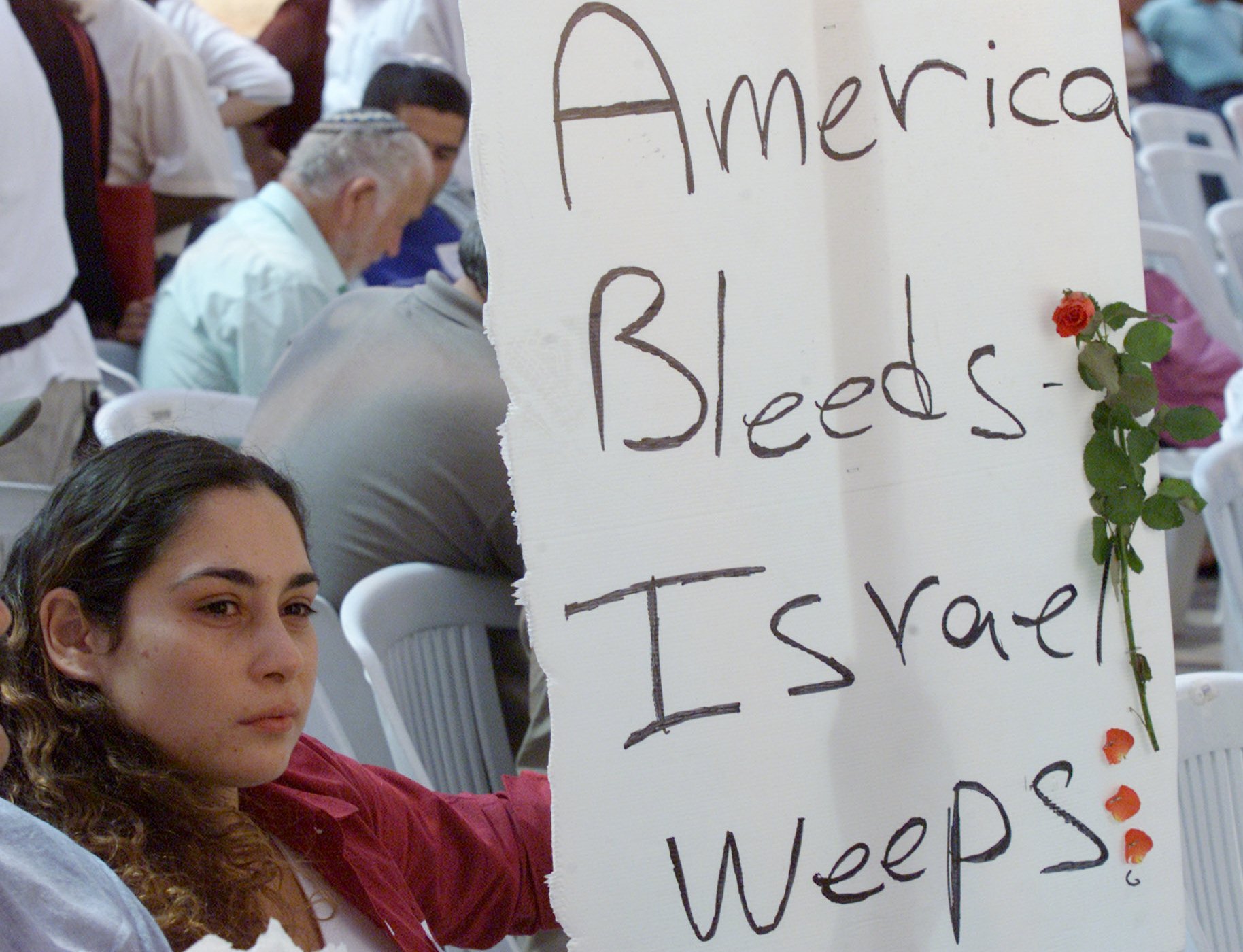 Israeli Moran Cohen, 23, whose younger brother Shai was killed while stationed as an Israeli soldier in the West Bank town of Hebron, holds a sign in support of the victims of Sept. 11 attacks in the United States during a ceremony in Jerusalem Wednesday, Sept. 12, 2001. (Lefteris Pitarakis, AP Photo)