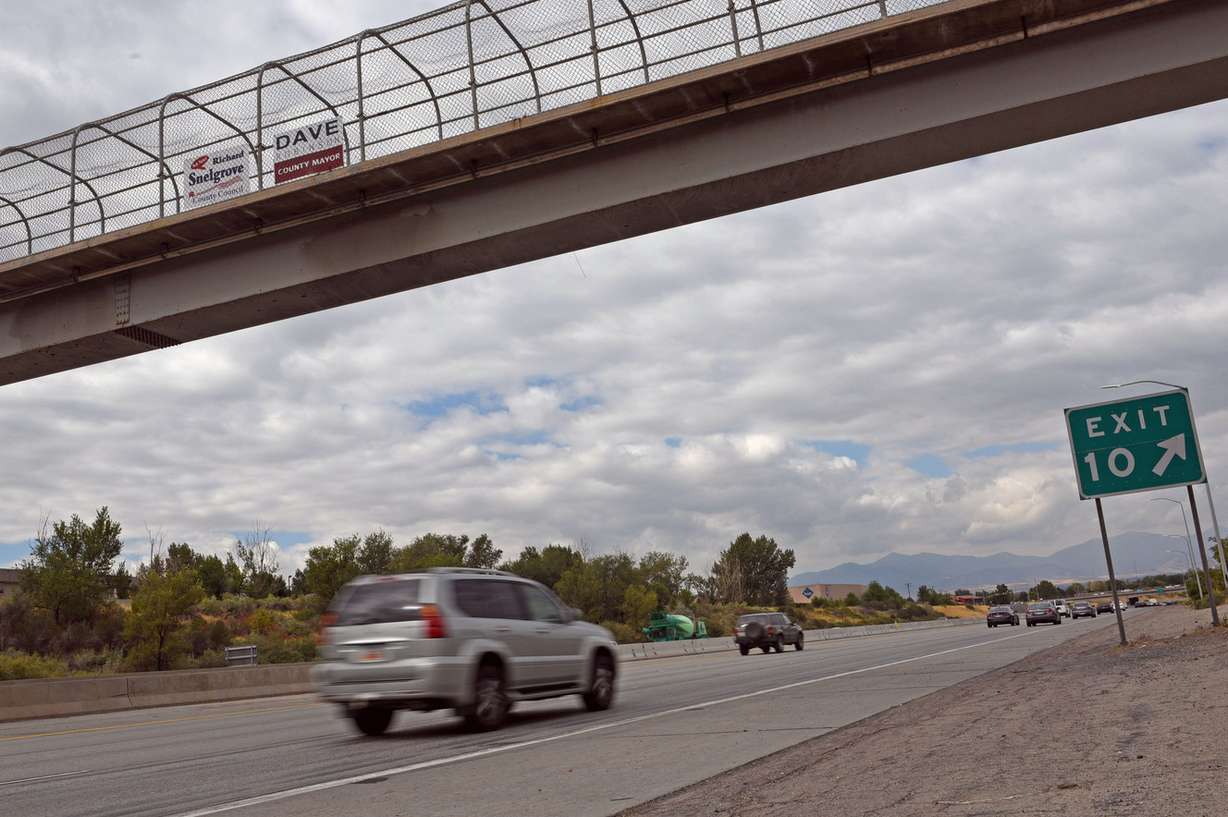 A vehicle passes under a campaign sign for Salt Lake County Councilman Richard Snelgrove on I-215 near Fashion Boulevard in Murray on Thursday, Sept. 15, 2016. Snelgrove's opponent, Catherine Kanter, discussed the use of illegal campaign signs by Snelgrove and outlined her concerns over the misuse of taxpayer dollars, asking for action on the issue at a press conference Thursday morning. (Photo: Nick Wagner, Deseret News)