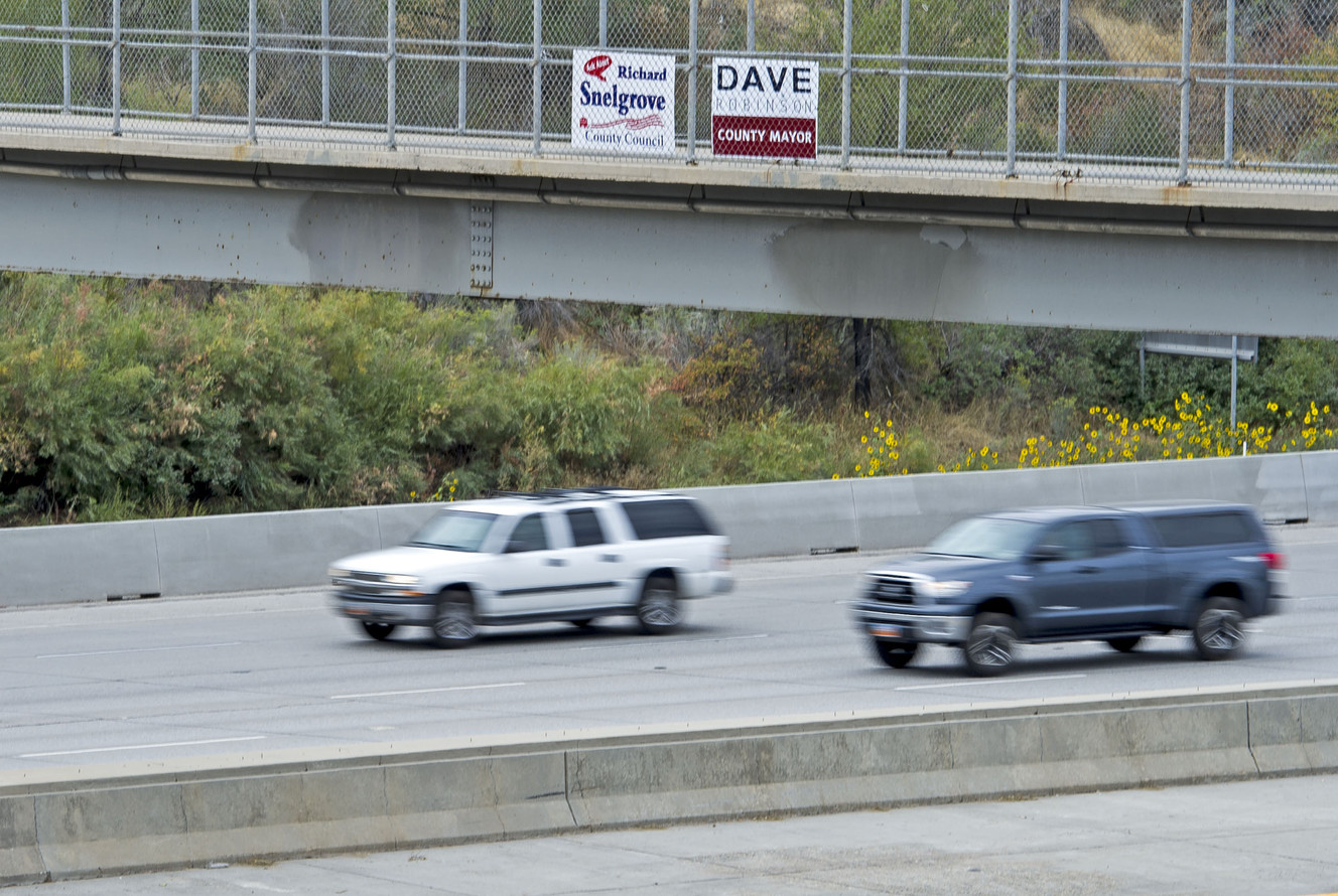 A campaign sign for Salt Lake County Councilman Richard Snelgrove is fixed to a pedestrian bridge over I-215 in Murray on Thursday, Sept. 15, 2016. Snelgrove's opponent, Catherine Kanter, discussed the use of illegal campaign signs by Snelgrove and outlined her concerns over the misuse of taxpayer dollars, asking for action on the issue at a press conference Thursday morning. (Photo: Nick Wagner, Deseret News)