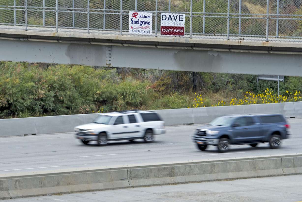 A campaign sign for Salt Lake County Councilman Richard Snelgrove is fixed to a pedestrian bridge over I-215 in Murray on Thursday, Sept. 15, 2016. Snelgrove's opponent, Catherine Kanter, discussed the use of illegal campaign signs by Snelgrove and outlined her concerns over the misuse of taxpayer dollars, asking for action on the issue at a press conference Thursday morning. (Photo: Nick Wagner, Deseret News)