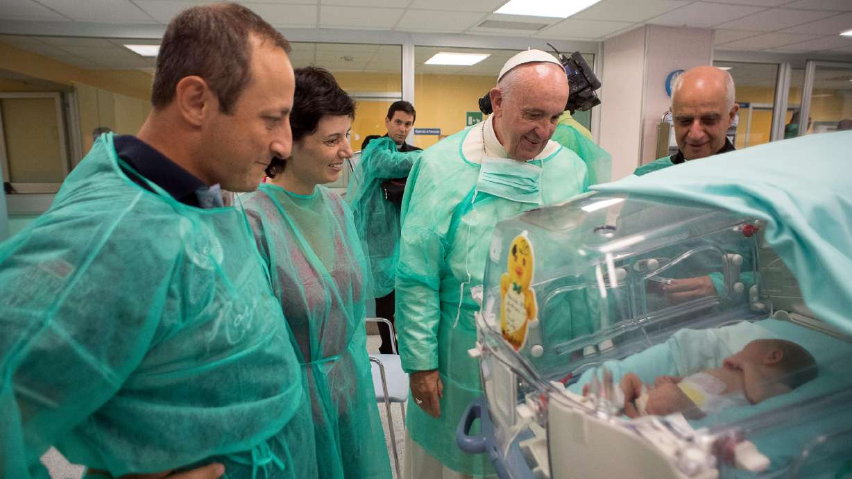 Pope dons scrubs to visit premature babies at Rome hospital