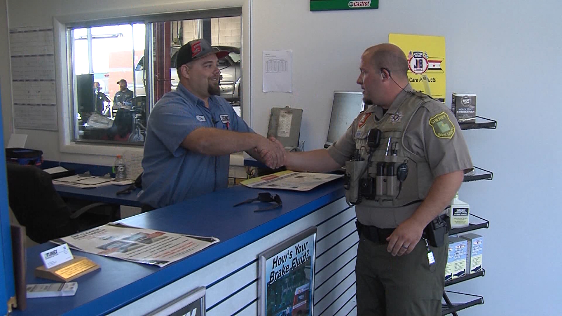 Deputy Christopher Pope, right, and Tunex manager Tim Smith, left, shake hands. (Photo: Ray Boone, KSL-TV)