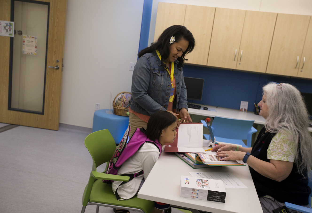 Zarahya Moors, 8, and her mother, Lalomanu, show teaching volunteer Cynthia Buchanan Zarahya's homework at the in-patient school at Primary Children's Hospital in Salt Lake City on Wednesday, Sept. 14, 2016. (Photo: Laura Seitz, Deseret News)