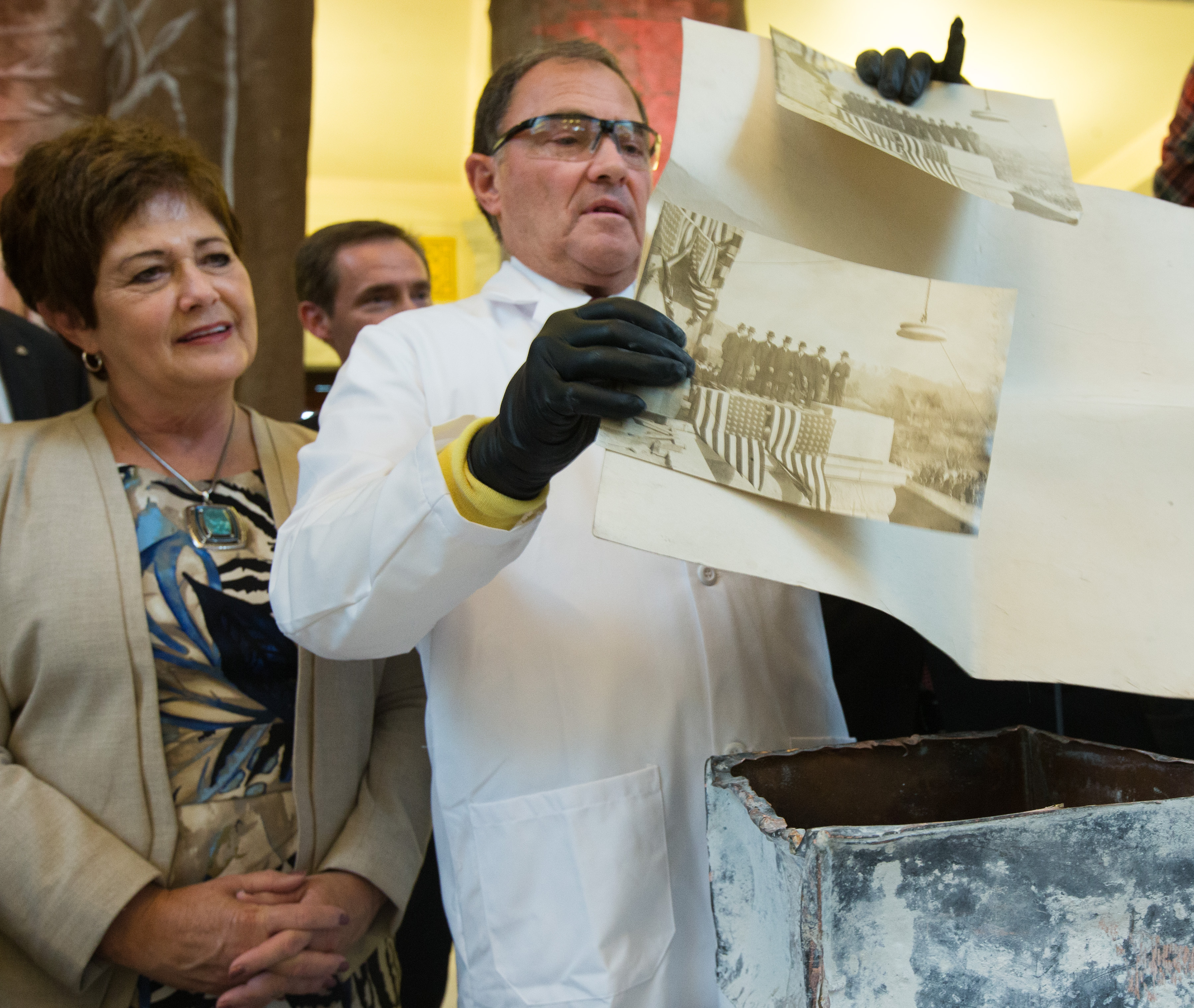 Governor Gary R. Herbert, and his wife Jeanette look at photographs found in a 100 year old time capsule that was removed from the capitol earlier during a ceremony in to rotunda on Monday, Oct. 3, 2016. (Photo: Scott G. Winterton, Deseret News)