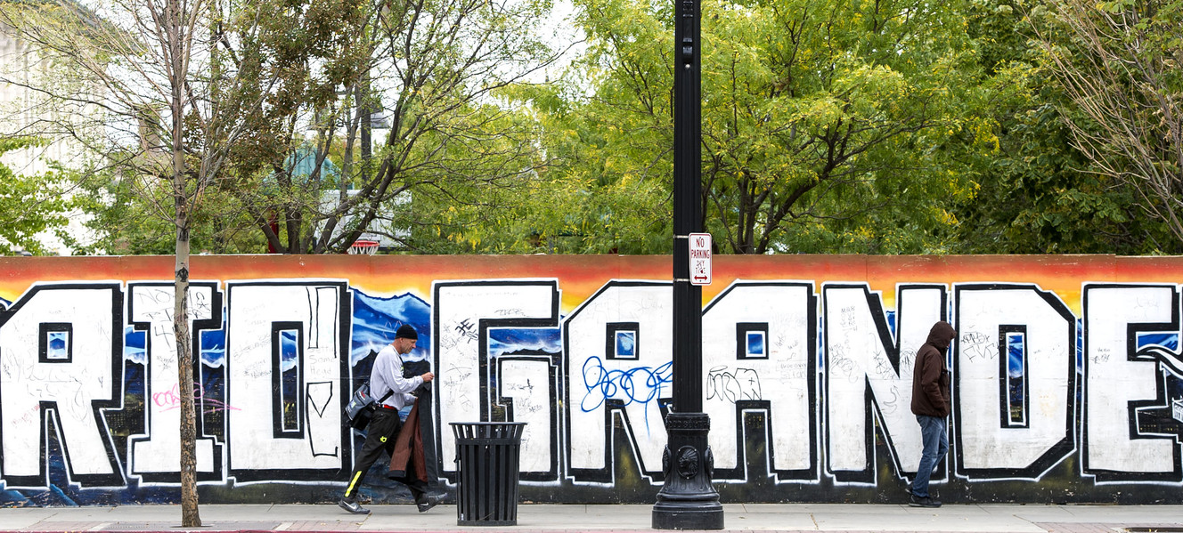 Two homeless men walk past a mural indicating the start of the Rio Grande neighborhood in Salt Lake City on Monday, Oct. 3, 2016. (Photo: Nick Wagner, Deseret News)
