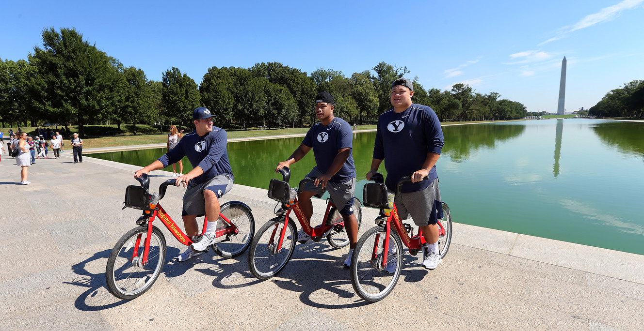 Graham Rowley, a student assistant and players Travis Tuiloma and Handsome Taunielu ride bikes as members of the BYU football team and fans tour the National Mall in Washington, D.C. on Friday, Sept. 23, 2016. (Photo: Scott G Winterton, Deseret News)