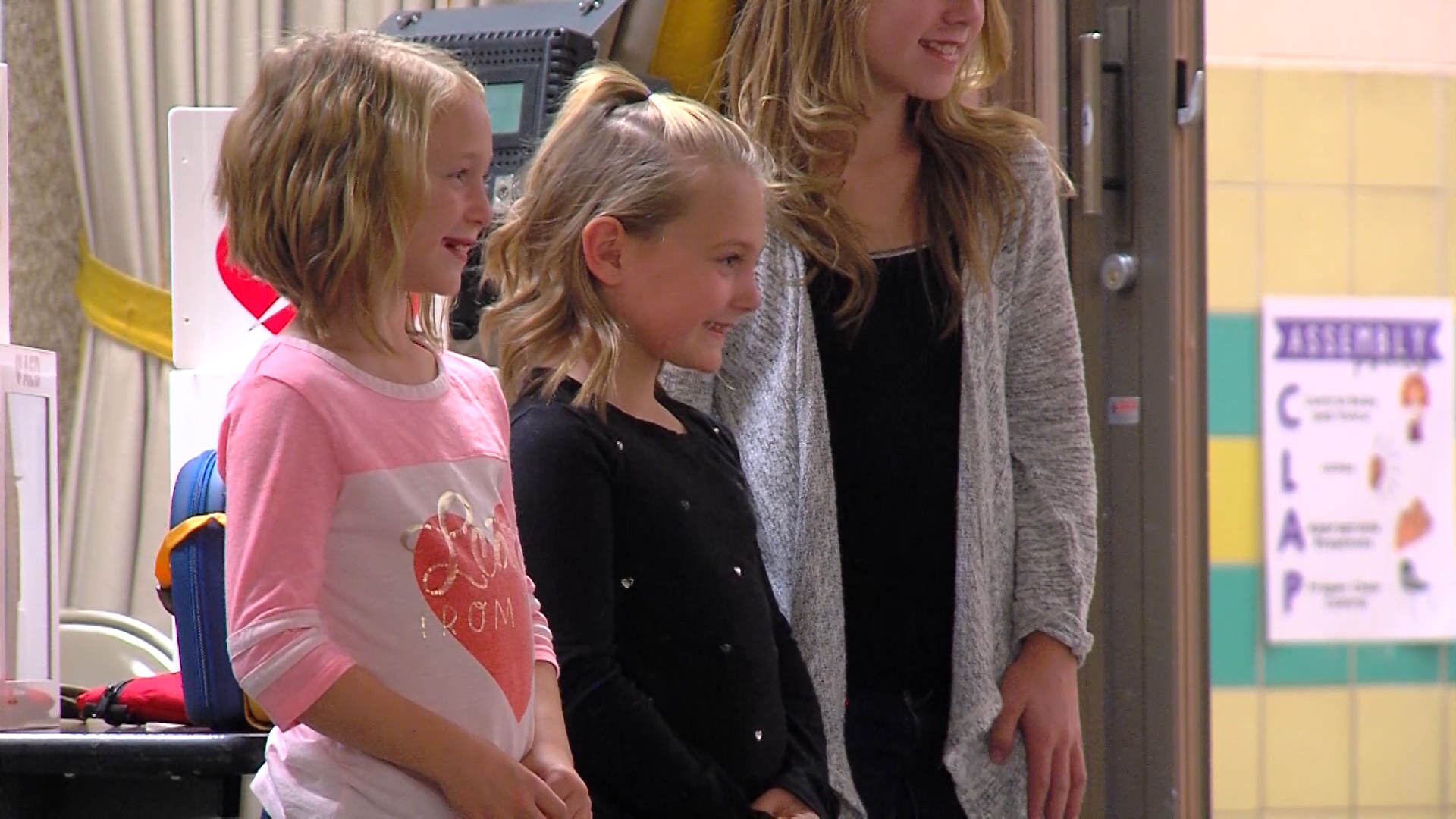 Tayton Timothy (center) stands next to Sabrina (left) and Sophia Johnson (right) during an assembly Friday at Kanesville Elementary School (Photo: Mark Debernardo, KSL-TV)