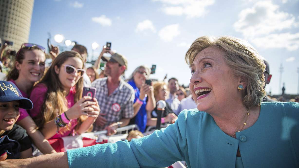 Trump hits 'corrupt' Hillary Clinton; Mrs. Obama hugs her