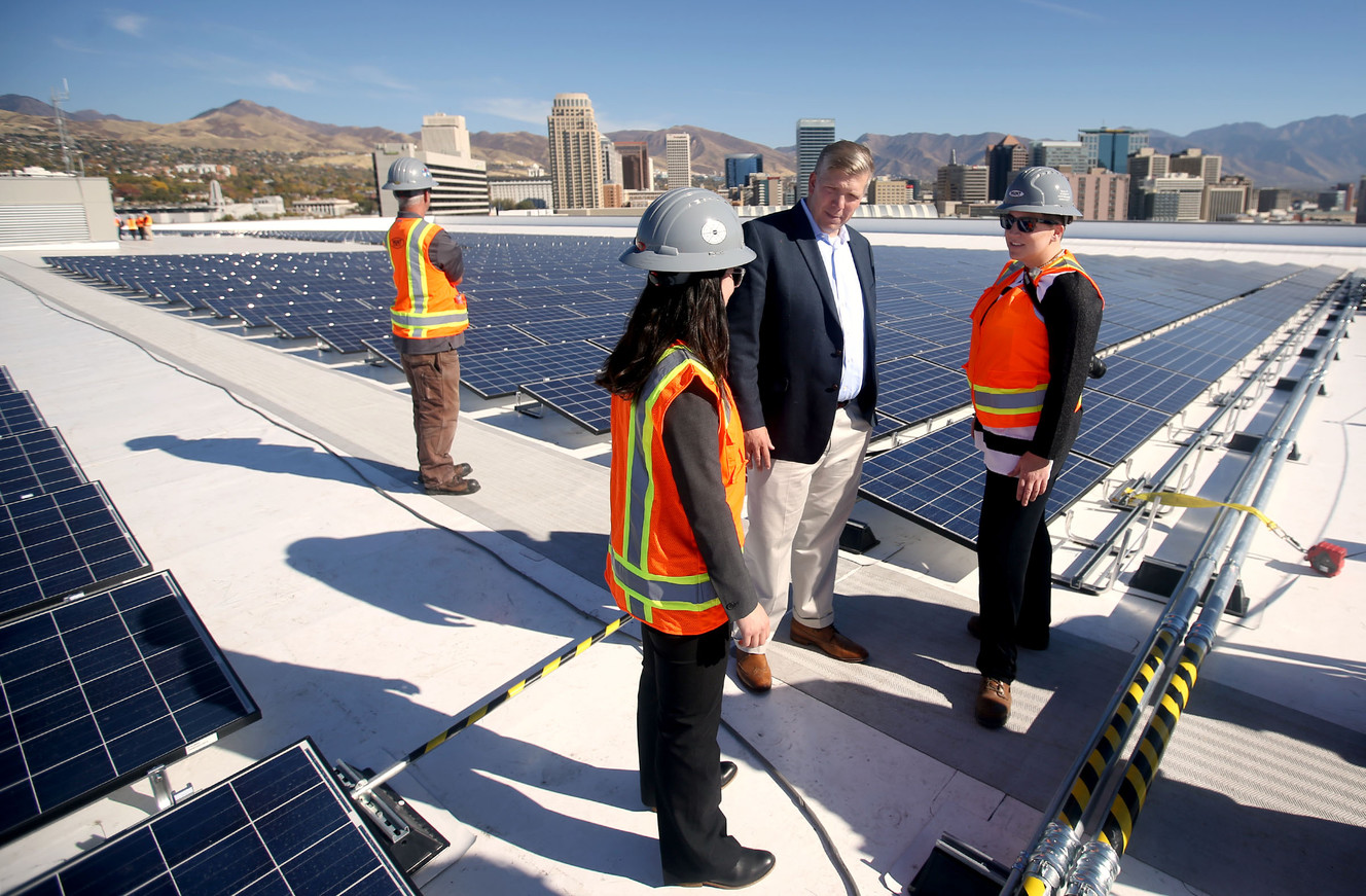 Vivint Solar CEO David Bywater, Shawna Cuan of the Governor's Office of Energy Development, and Deb Henry of Hunt Electric Inc.'s renewable energy division, discuss the new rooftop solar installation at Vivint Smart Home Arena in Salt Lake City on Wednesday, Oct. 26, 2016. Photo: Laura Seitz, Deseret News