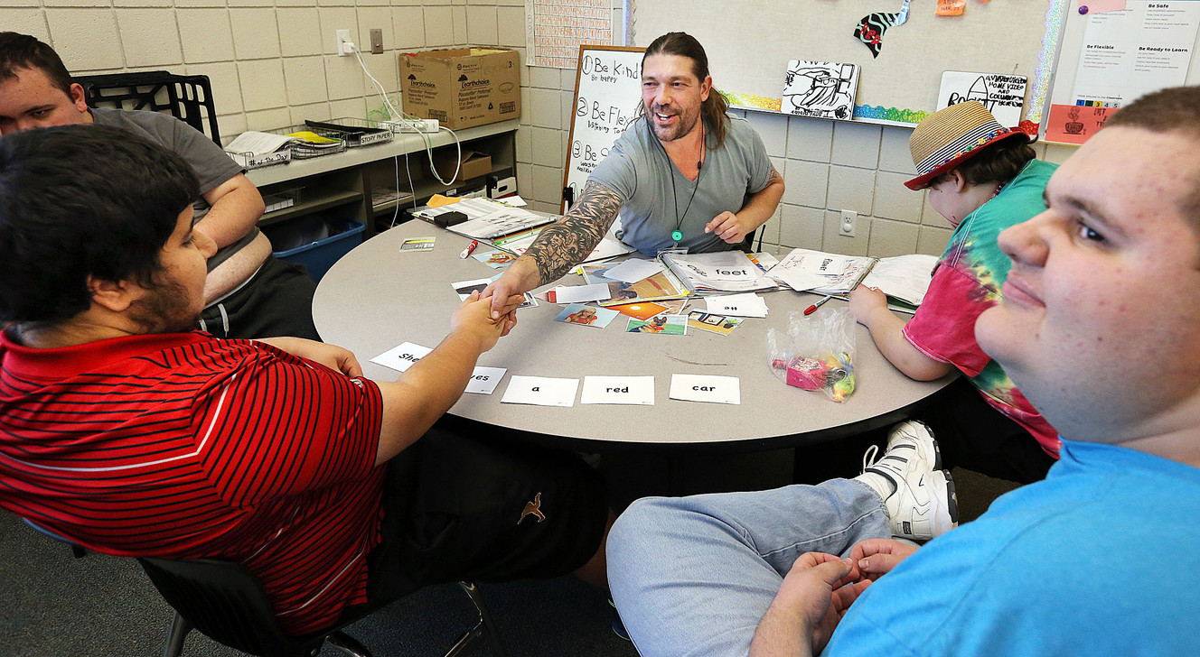 Autism specialist Leonardo Panizza, center, congratulates student Shuaib, left, for his work at the Carmen B. Pingree Autism Center of Learning in Salt Lake City on Wednesday, Oct. 26, 2016. At right is student Gavynn. (Photo: Ravell Call, Deseret News)