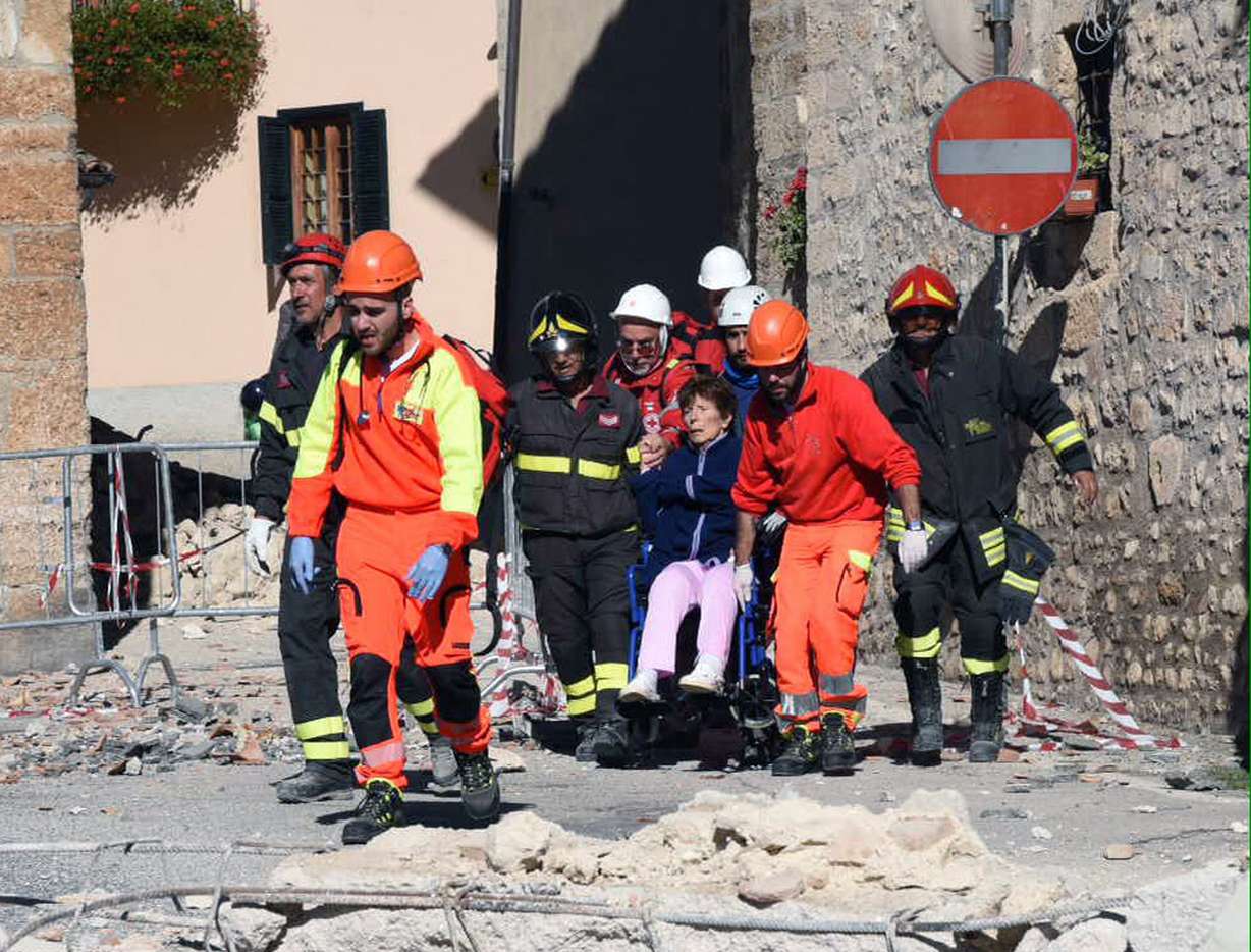 A woman on a wheelchair is carried away by rescuers in Norcia, central Italy, after an earthquake with a preliminary magnitude of 6.6 struck central Italy, Sunday, Oct. 30, 2016. A powerful earthquake rocked the same area of central and southern Italy hit by quake in August and a pair of aftershocks last week, sending already quake-damaged buildings crumbling after a week of temblors that have left thousands homeless. (Matteo Crocchioni, ANSA via AP)