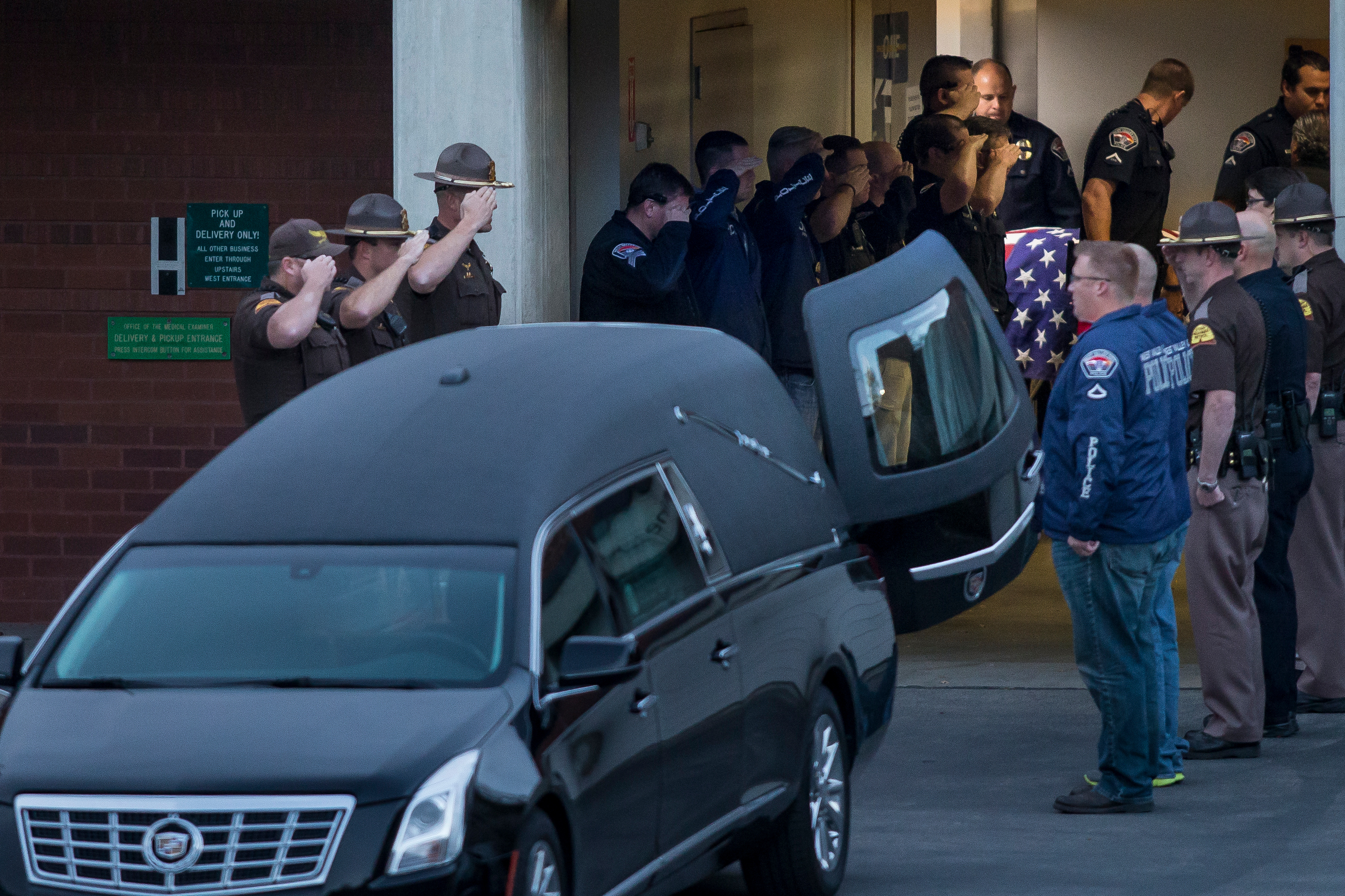 Law enforcement officers salute as a casket containing the body of West Valley City police officer Cody Brotherson is brought to a waiting hearse at the State Medical Examiner's Office in Salt Lake City on Sunday, Nov. 6, 2016. (Photo: Spencer Heaps, Deseret News)