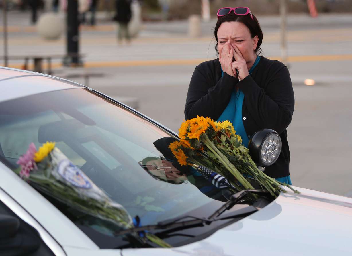 Tari Turner brings flowers to the patrol car of her nephew, West Valley police officer Cody Brotherson, outside the police station in West Valley City on Monday, Nov. 7, 2016. Brotherson was killed in the line of duty Sunday. (Kristin Murphy, Deseret News)