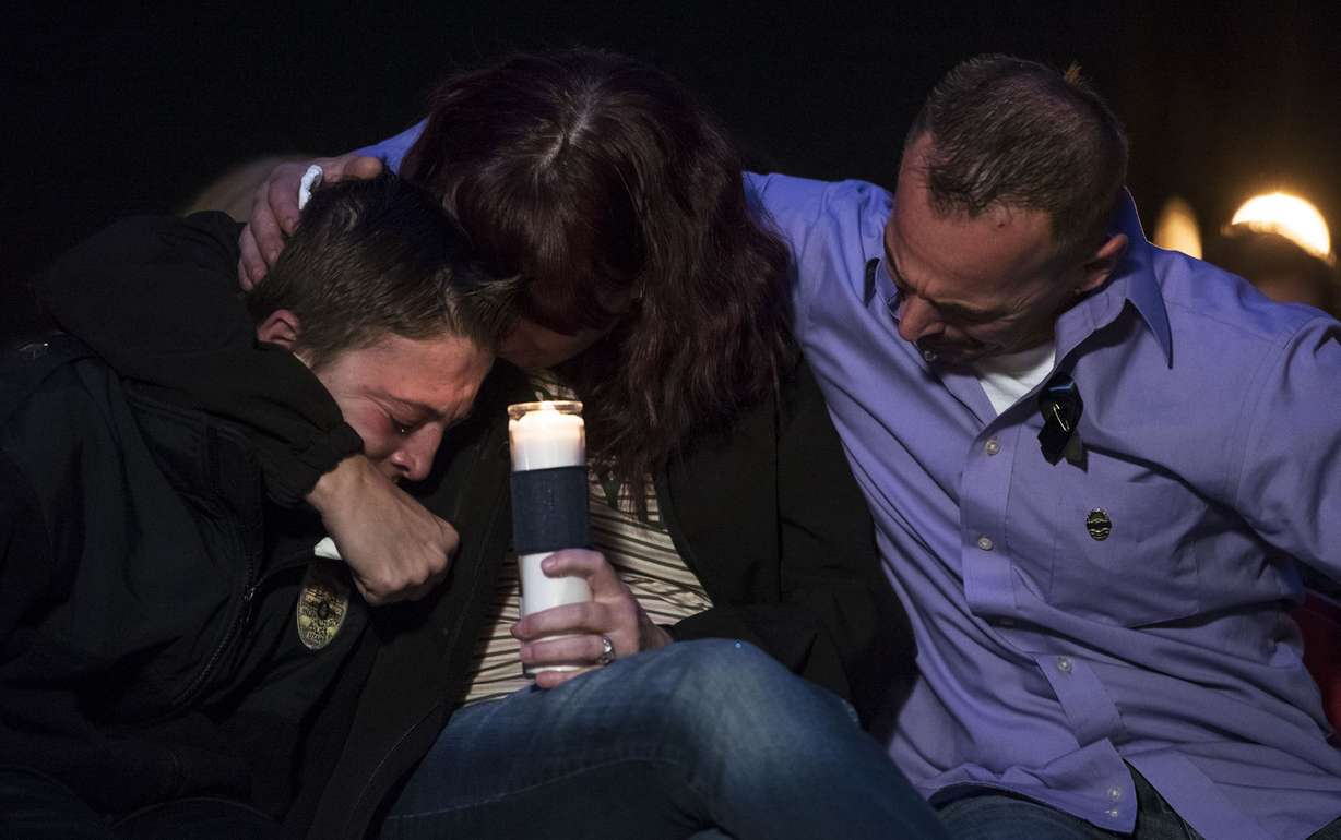 Jenny and Jeff Brotherson, the parents of fallen West Valley City police officer Cody Brotherson, embrace their son, Alex, during a vigil in West Valley City on Wednesday, Nov. 9, 2016. (Photo: Nick Wagner, Deseret News)