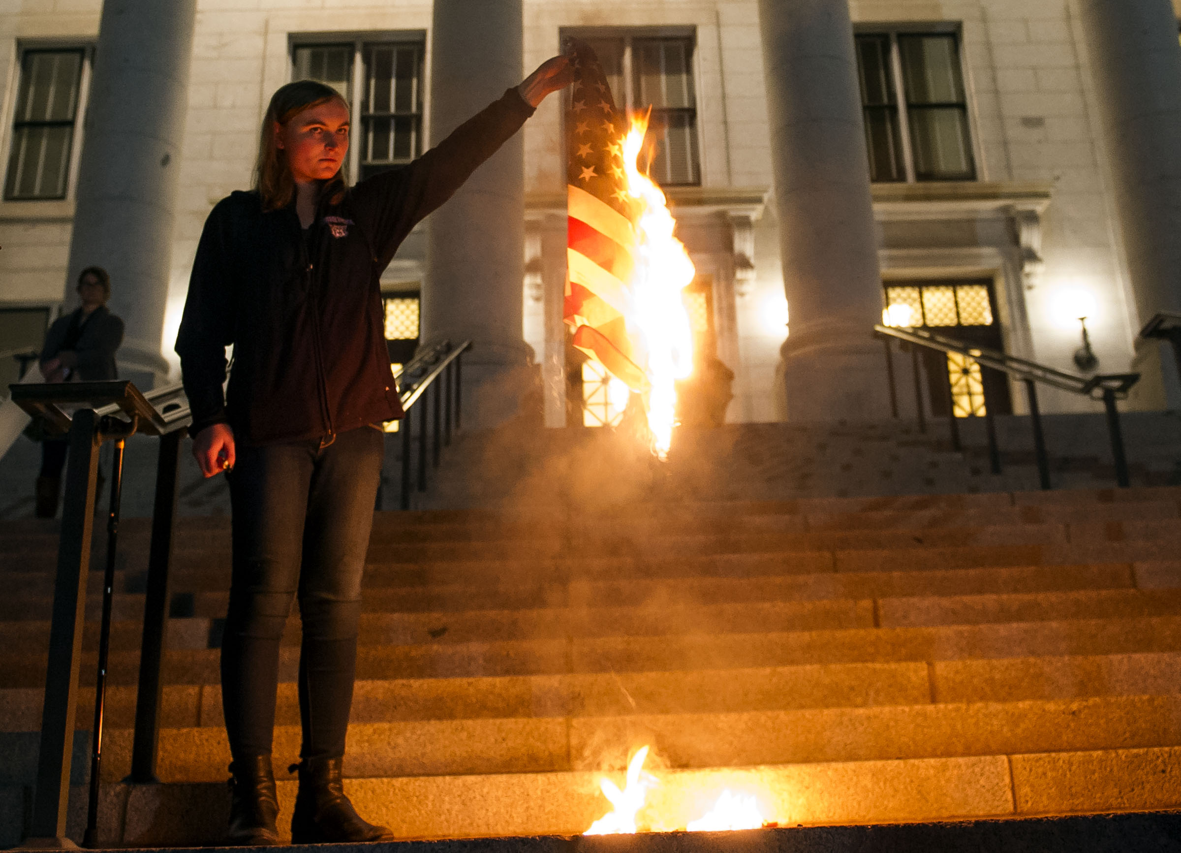 A woman burns the American flag during an anti-Trump protest in Salt Lake City on Thursday, Nov. 10, 2016. A law enforcement official respected her right to freedom of speech, but ultimately made her extinguish the flames after she left the flag burning on the steps of the capitol. Hundreds of protestors took to the streets to denounce the president-elect, and ultimately made their way to the state capitol building. (Photo: Nick Wagner, Deseret News)