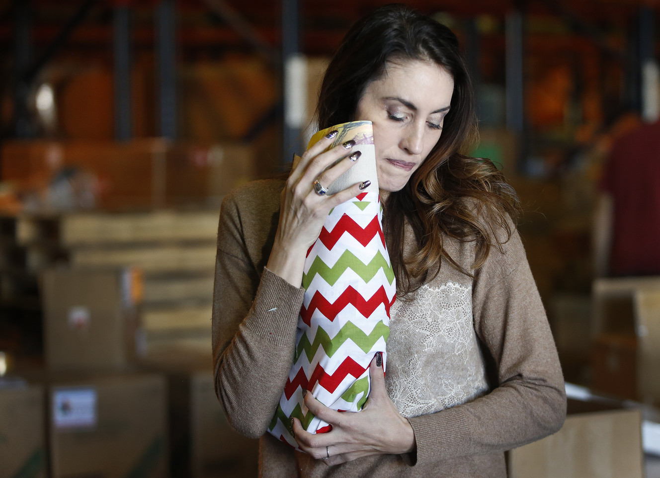 Carolyn Norris hugs and kisses each stocking she stuffs as volunteers fill more than 10,000 Christmas stockings in support of Operation Christmas Stocking in Salt Lake City on Friday, Nov. 11, 2016. (Photo: Jeffrey D. Allred, Deseret News)
