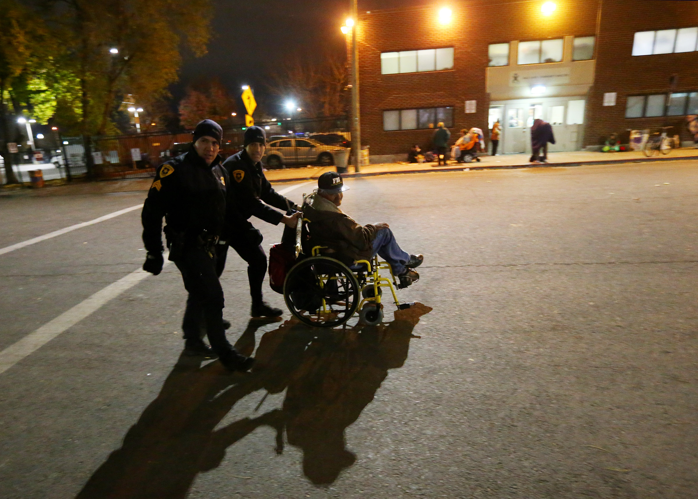 Salt Lake City police officers, Sgt. Bill Manzanares and officer Harrison Livsey bring a homeless man to the winter overflow shelter at St. Vincent de Paul in Salt Lake City as it opens just ahead of a winter storm on Wednesday, Nov. 16, 2016. (Photo: Scott G. Winterton, Deseret News)