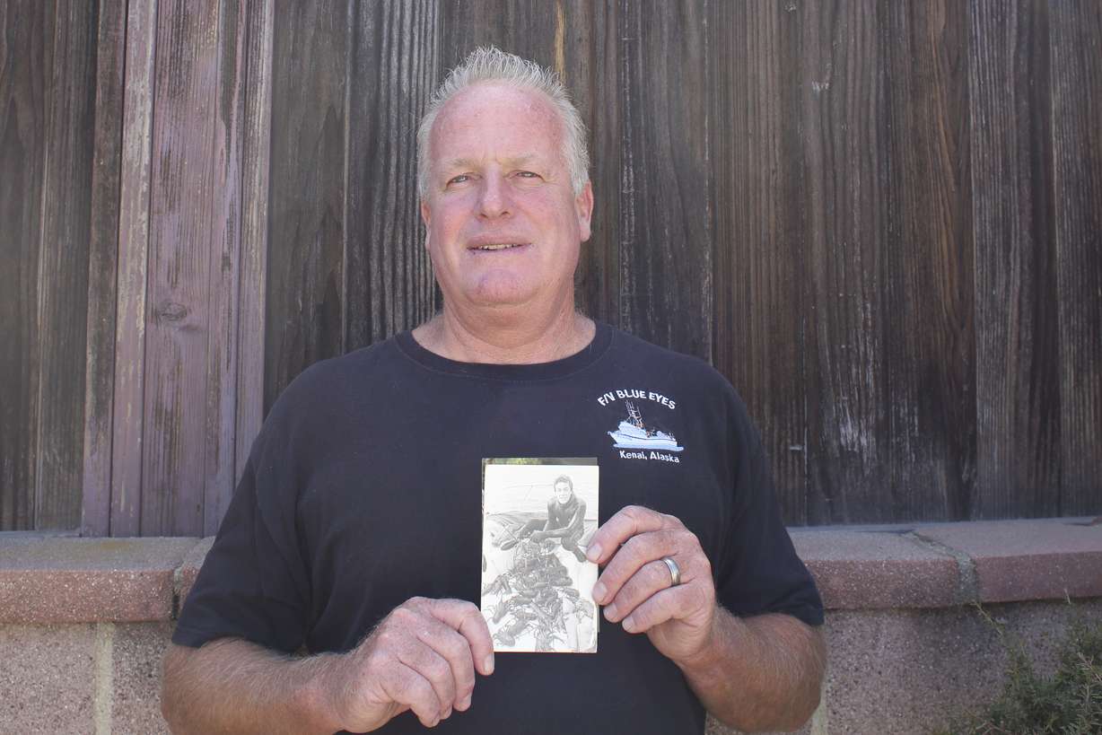 In this July 8, 2016, photo, Tim Bridger holds a photo of his younger brother, Michael, in Redondo Beach, Calif. Michael was a skilled diver and worked in and around the water most of life. Michael Bridger died on Sept. 21, 2012, after suffering a heart attack while cleaning a 24-foot tank being prepared for a scene in the film “The Lone Ranger.” Safety inspectors fined the film’s producers more than $61,000 for violating several safety protocols, including allowing a backup diver to leave Bridger in the water for 10 minutes, not having anyone with adequate CPR training on site, and not requiring health exams for divers being used on the film. (AP Photo/Anthony McCartney)