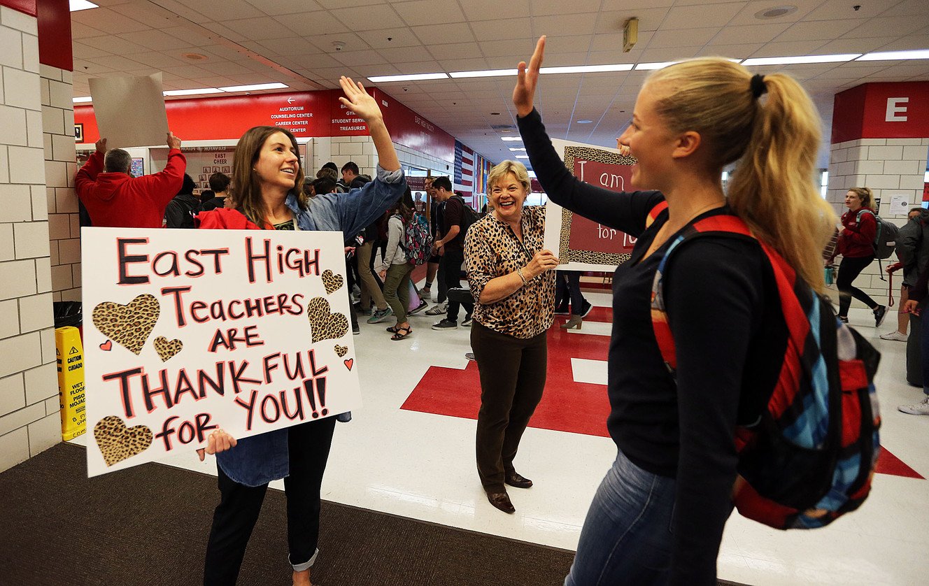 Teachers Blair Porter, left, and Bev Simpson hold signs and greet student Elsa Hamberg at East High School in Salt Lake City on Tuesday, Nov. 22, 2016. The activity was held to let students know they are welcome and valued. Photo: Ravell Call, Deseret News