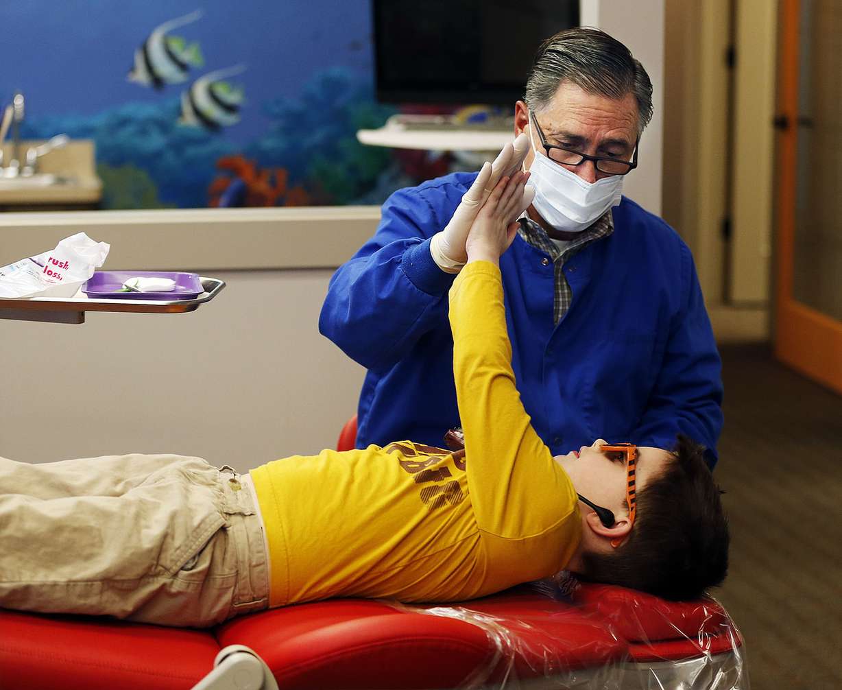 Dentist Scott Wall high-fives Dawson McGraw after a dental exam at Kidz Dental Works in Kaysville on Monday, Dec. 5, 2016. (Photo: Ravell Call, Deseret News)