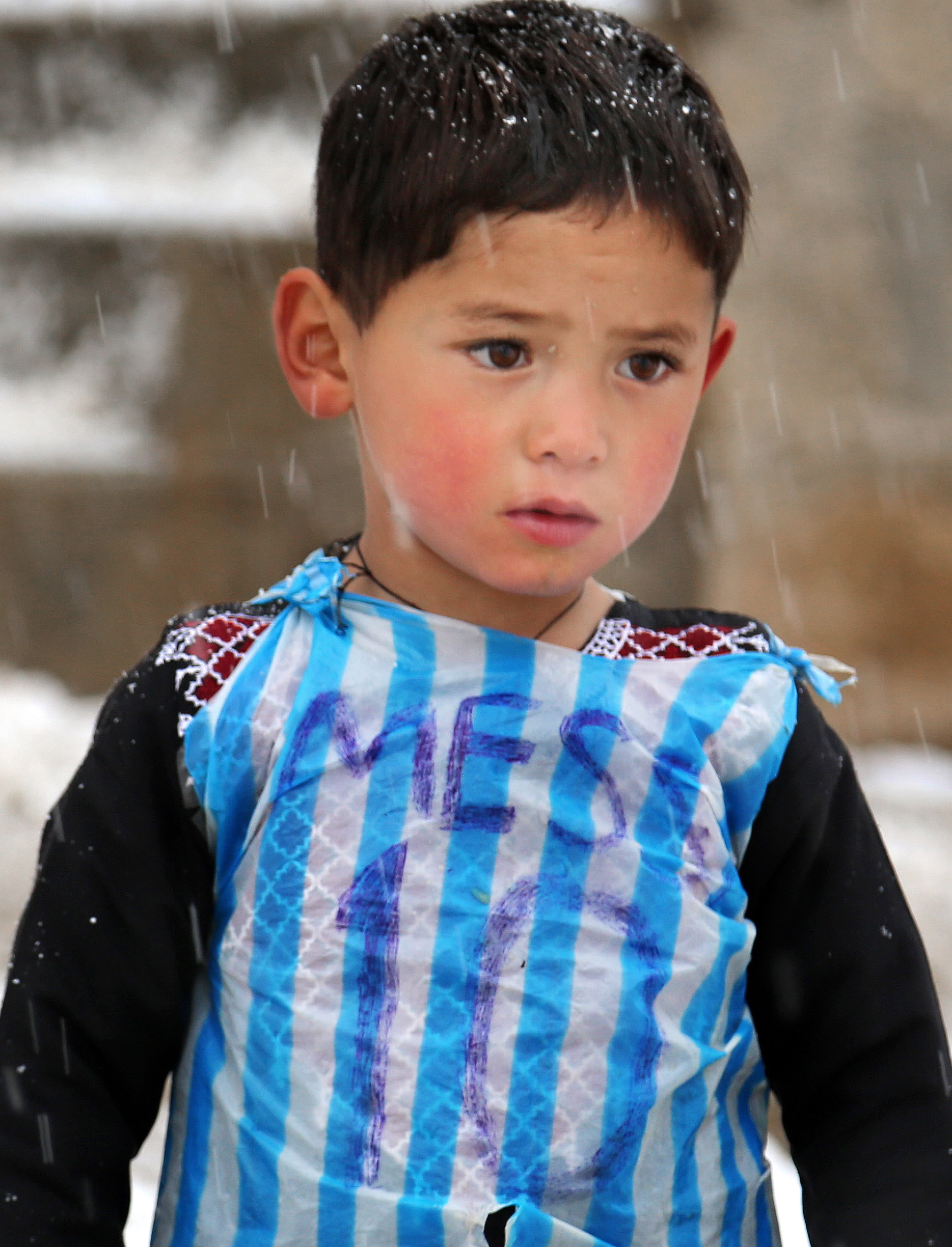 In this Friday, Jan. 29, 2016 photo, Murtaza Ahmadi, a five-year-old Afghan Lionel Messi fan plays football near his home, in the Jaghori district of Ghazni in Afghanistan. The Afghan Football Federation plans to set up a meeting between Messi and Ahmadi who became an Internet sensation when photos circulated of him wearing an improvised Messi shirt made from a plastic bag. (AP Photo)