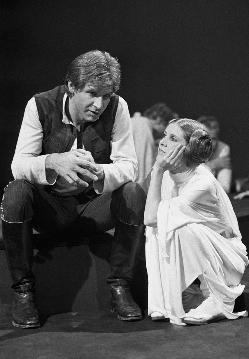 In this Nov. 13, 1978 file photo, Harrison Ford talks with Carrie Fisher during a break in the filming of the CBS-TV special "The Star Wars Holiday" in Los Angeles. On Tuesday, Dec. 27, 2016, a publicist says Fisher has died at the age of 60. (AP Photo/George Brich, File)