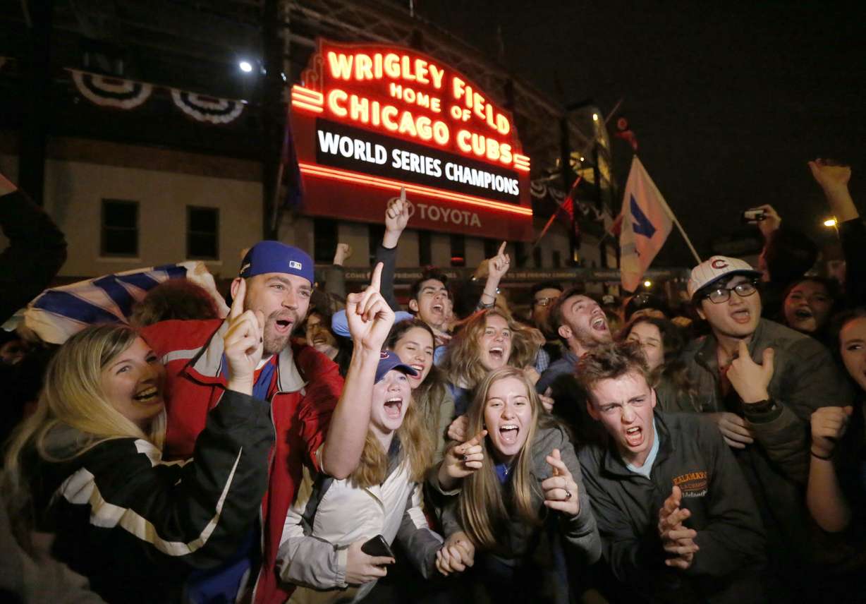Chicago Cubs fans celebrate in front of Wrigley Field in Chicago on Wednesday, Nov. 2, 2016, after the Cubs defeated the Cleveland Indians 8-7 in Game 7 of the baseball World Series in Cleveland. (Charles Rex Arbogast, AP Photo)