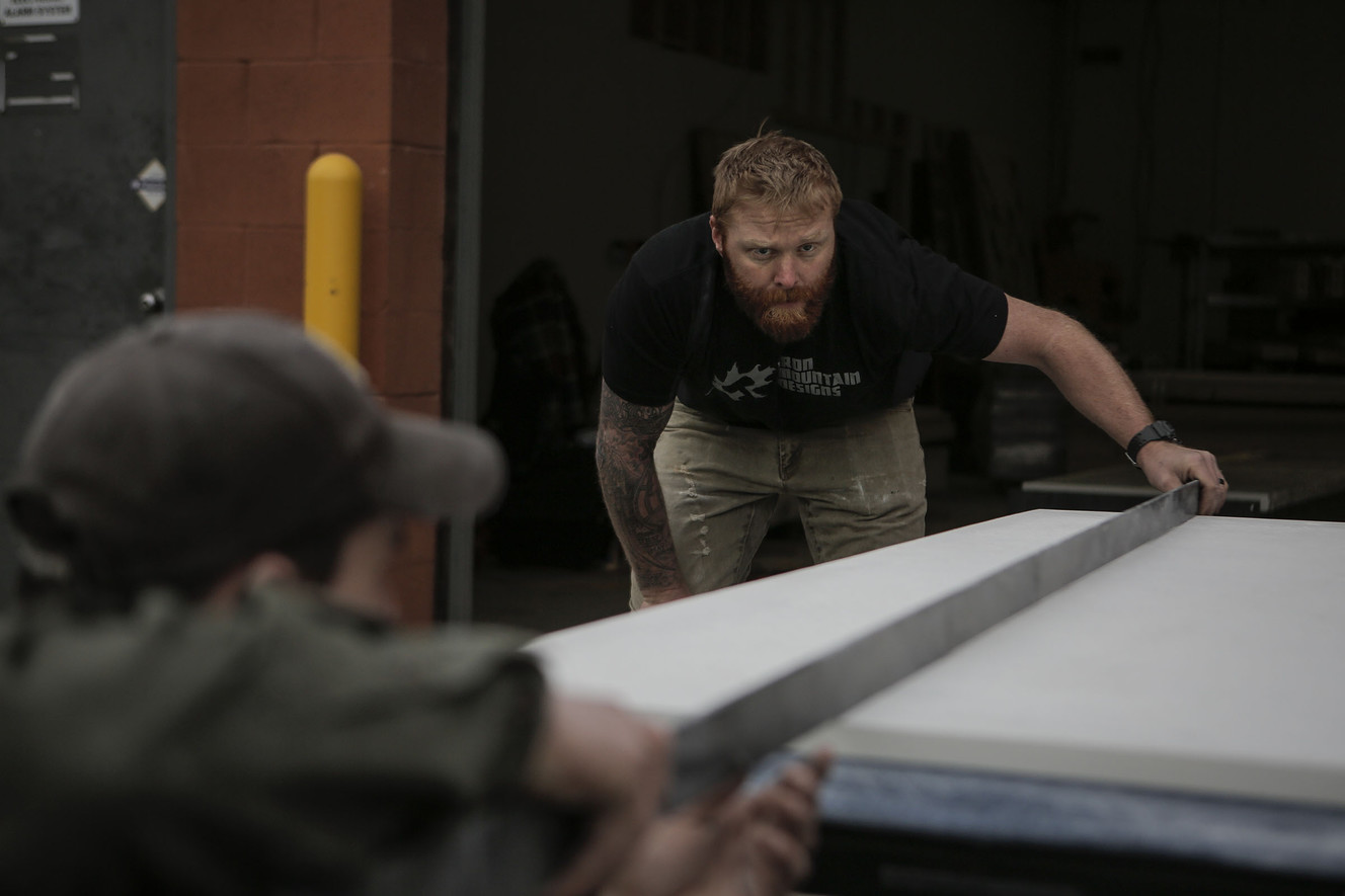 Evan Smail, left, mechanical engineer at Iron Mountain Designs, helps Josh Vandenbrink, the company's president, right, measure a sheet of concrete for a project for outdoor clothing company Arc'teryx in Salt Lake City on Friday, Jan. 13, 2017. (Photo: Nicole Boliaux, Deseret News)