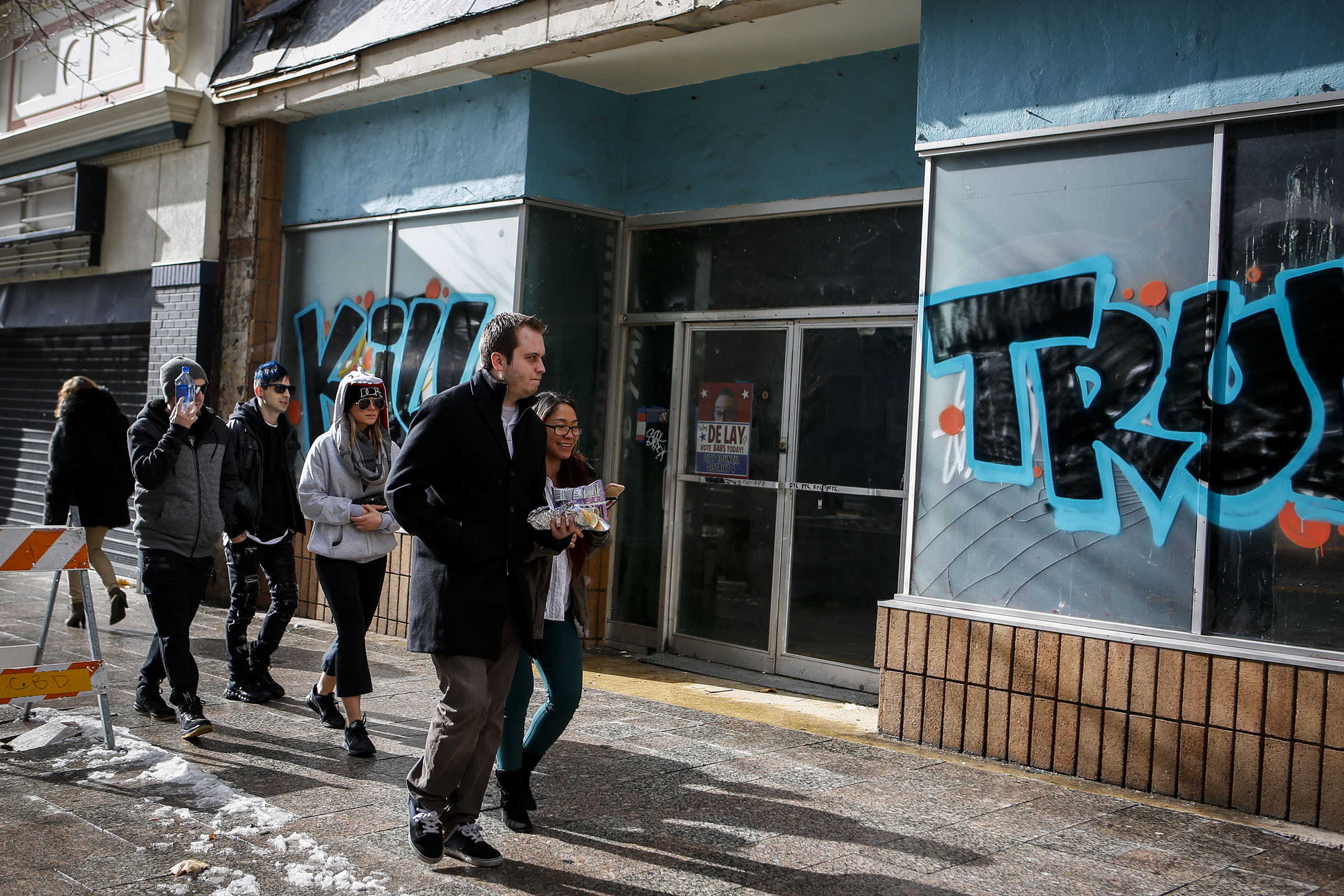 People walk past anti-Trump graffiti on a building at 254 S. Main in Salt Lake City on Friday, Jan. 20, 2017. The graffiti appeared after President Trump was sworn into office. (Photo: Nicole Boliaux, Deseret News)