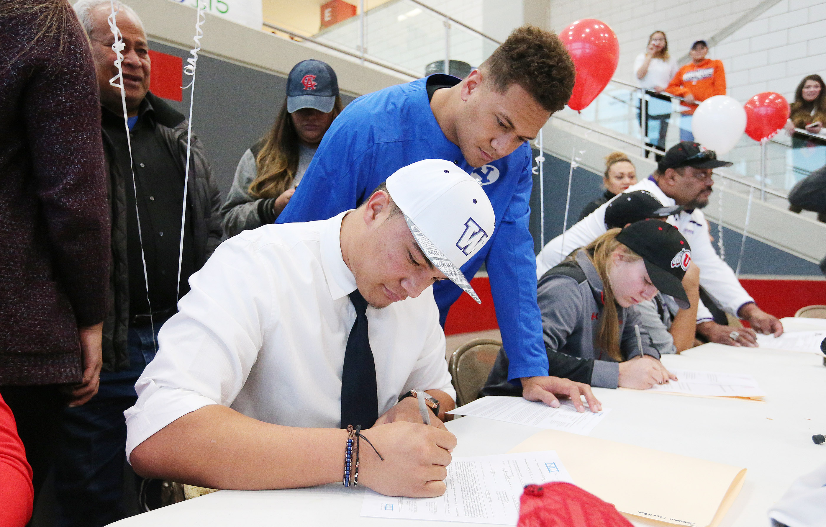 East High School's Jordan Lolohea signs with Washington under the supervisor of his brother AJ who will be playing for BYU during letter of intent signing day in Salt Lake City on Wednesday, Feb. 1, 2017. (Photo: Jeffrey D. Allred, Deseret News)
