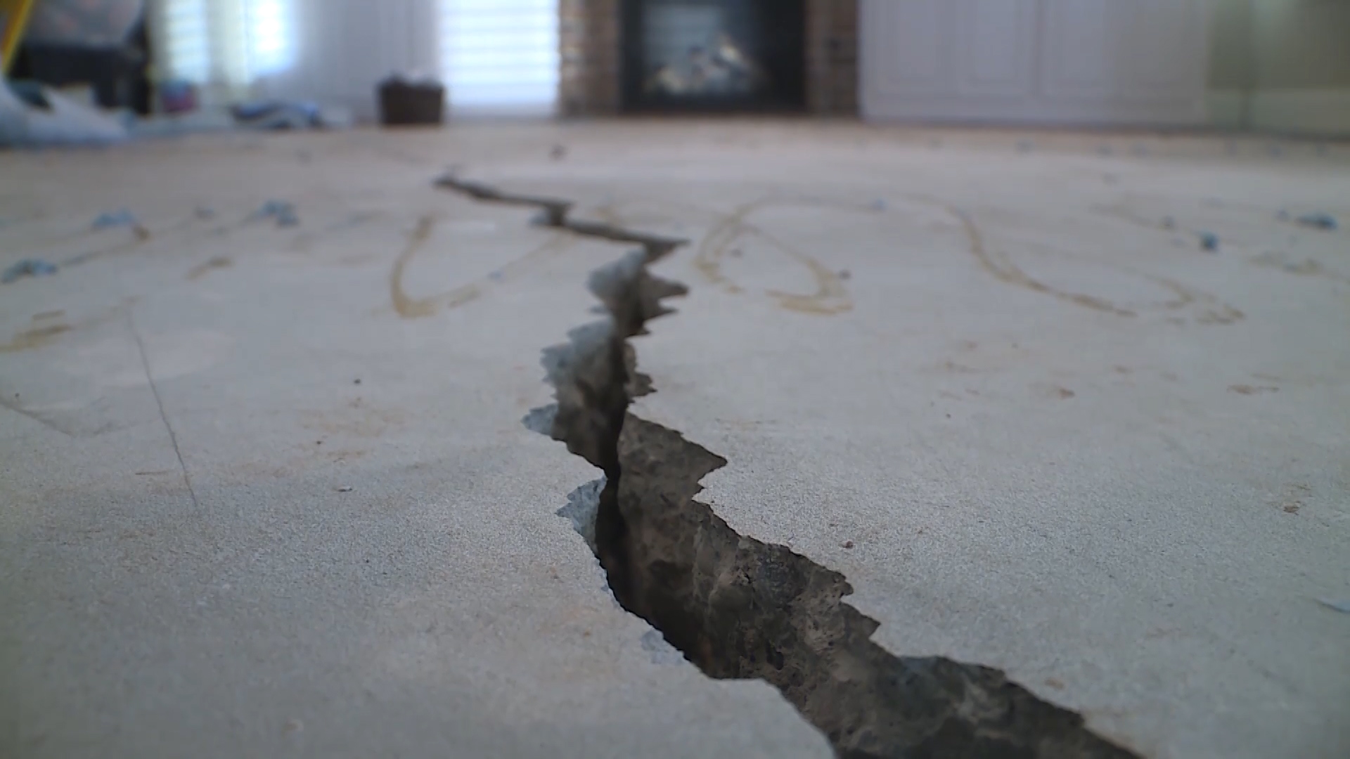 A crack runs through the floor of Bennett and Kassie Thurgood's abandoned dream home on Hampton Ridge Drive in Ogden. (Photo: Steve Breinholt, KSL TV)
