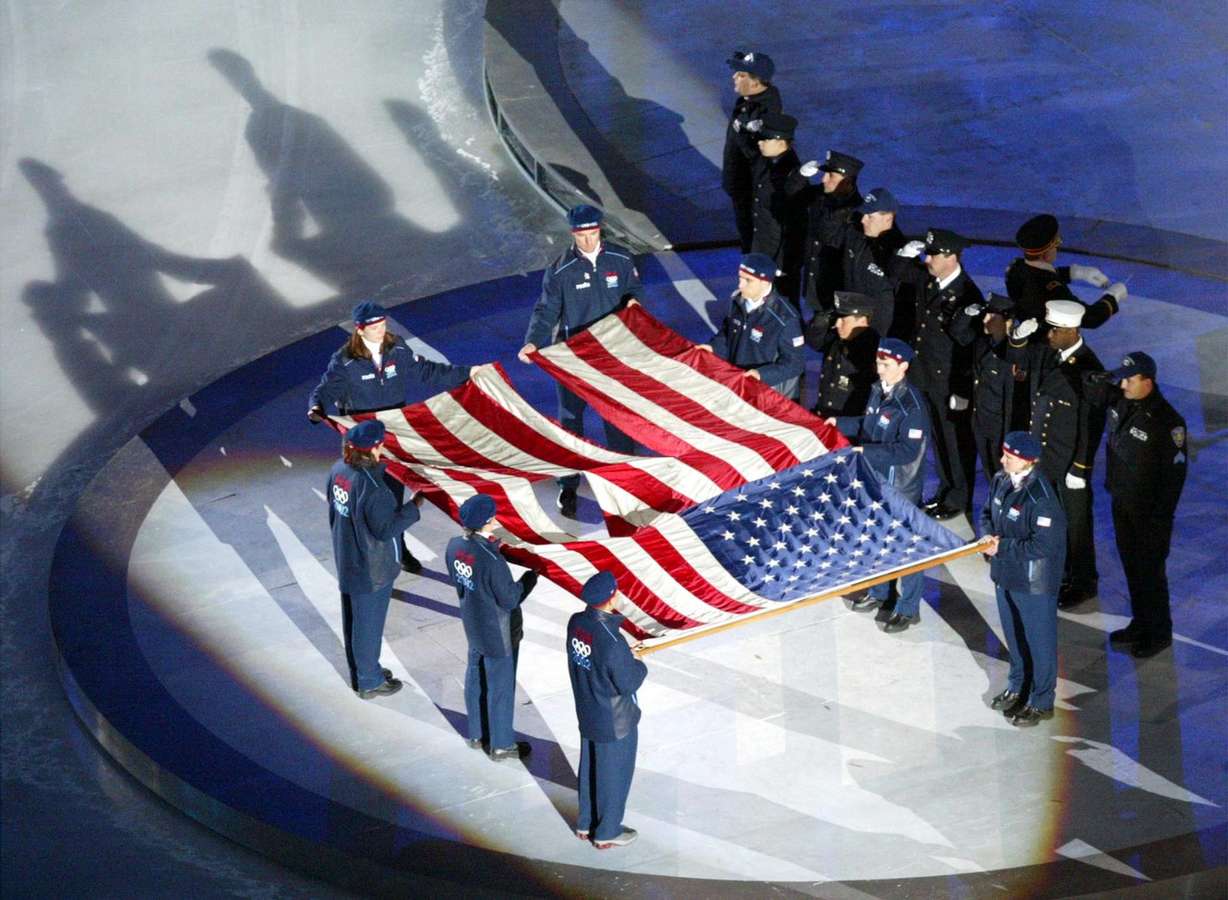 The World Trade Center flag is presented by members of the New York Police and Fire Department at the Opening Ceremonies of the Salt Lake 2002 Winter Olympic Games at Rice-Eccles Stadium Friday, February 8, 2002. (Photo: Stuart Johnson, The Deseret News)