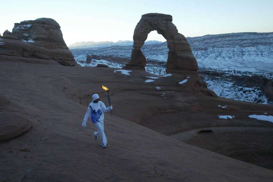 Native American Stephanie Laree Spann walks the Olympic Torch past Delicate Arch in Arches National Park, near Moab, Utah on Feb. 2, 2002. (Photo: Tom Smart, Deseret News, File)