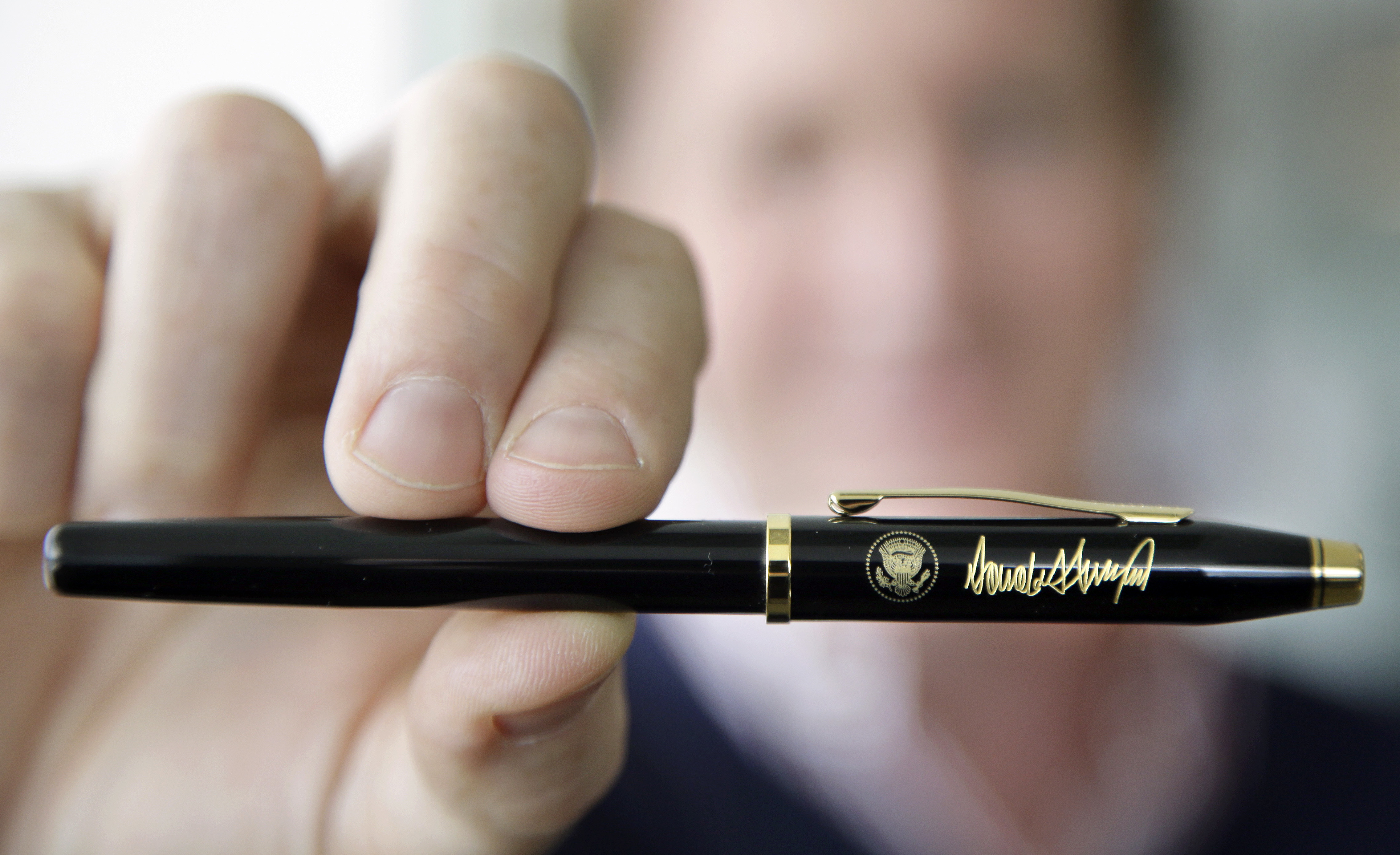 In this Tuesday, Feb. 14, 2017, photo Andy Boss, who manages business gift sales for Rhode Island-based A.T. Cross Co., displays a custom-made Cross Century II model pen designed for President Donald Trump at the Cross Company Store in Providence, R.I. (AP Photo/Steven Senne)