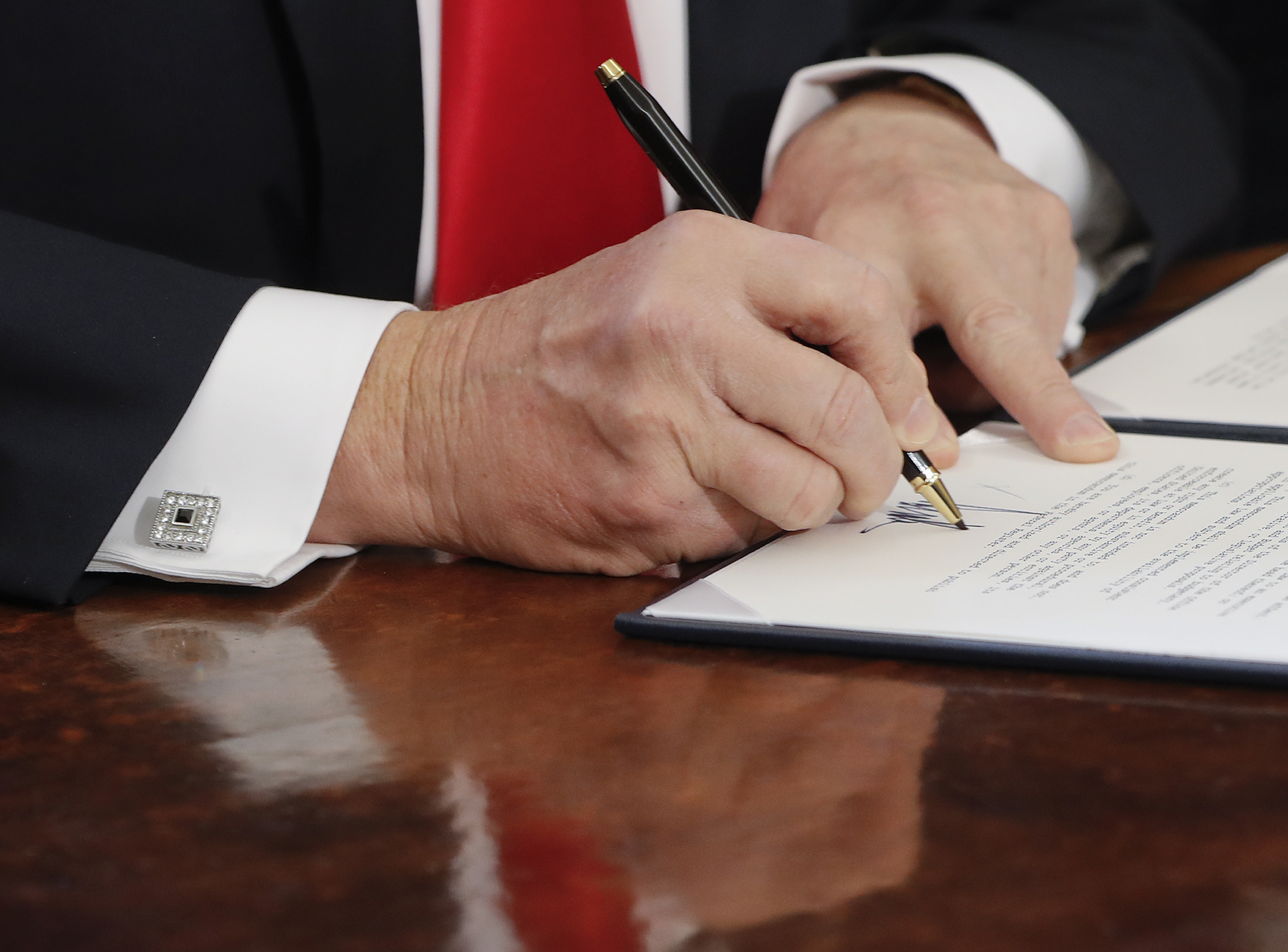In this Friday, Feb. 3, 2017, file photo President Donald Trump signs an executive order in the Oval Office of the White House in Washington. It didn't take long for President Donald Trump to start running out of the custom-made Cross pens he uses to sign all of his executive orders. "I think we're going to need some more pens, by the way," he said on inauguration day, after handing them out as souvenirs for lawmakers who attended his first signing ceremony. (AP Photo/Pablo Martinez Monsivais, File)