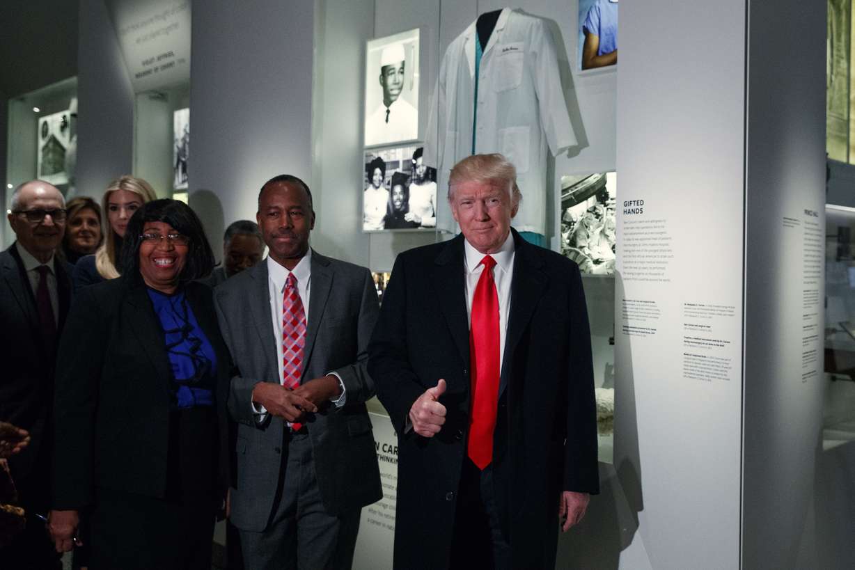 President Donald Trump walks with Housing and Urban Development Secretary-designate Dr. Ben Carson, as they pass a exhibit honoring Carson during a tour of the National Museum of African American History and Culture, Tuesday, Feb. 21, 2017, in Washington. (AP Photo/Evan Vucci)