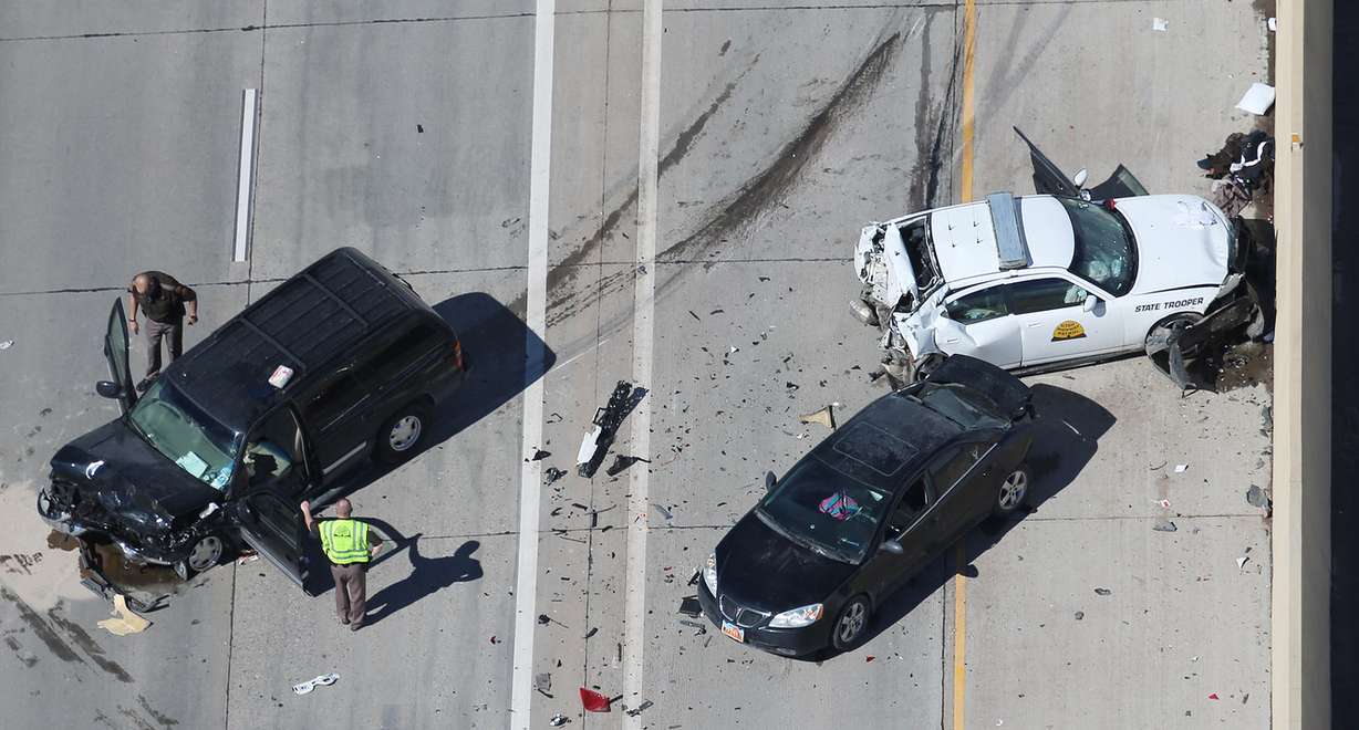 Officials investigate after Utah Highway Patrol trooper Devin Gurney was hit by a vehicle Monday, March 6, 2017, on I-15 near Lindon. According to UHP Sgt. Todd Royce, the trooper had pulled over another vehicle in the far left emergency lane of traffic about 11 a.m. when he his car was hit from behind. (Photo: Scott G Winterton, Deseret News)