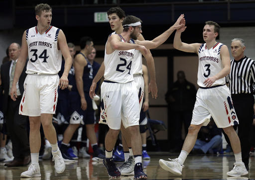 Saint Mary's Calvin Hermanson, center, and Emmett Naar, right, celebrate during a timeout during the second half of an NCAA college basketball game against BYU Thursday, Jan. 5, 2017, in Moraga, Calif. At left is St. Mary's center Jock Landale (34). (AP Photo, Ben Margot)