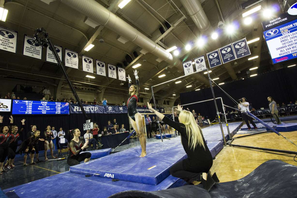 SUU freshman gymnast Becky Rozsa salutes the judges after completing a routine as her teammates celebrate in a meet between SUU and BYU at the George Albert Smith Fieldhouse on March 13, 2017. (Photo: Carter Williams, KSL.com)