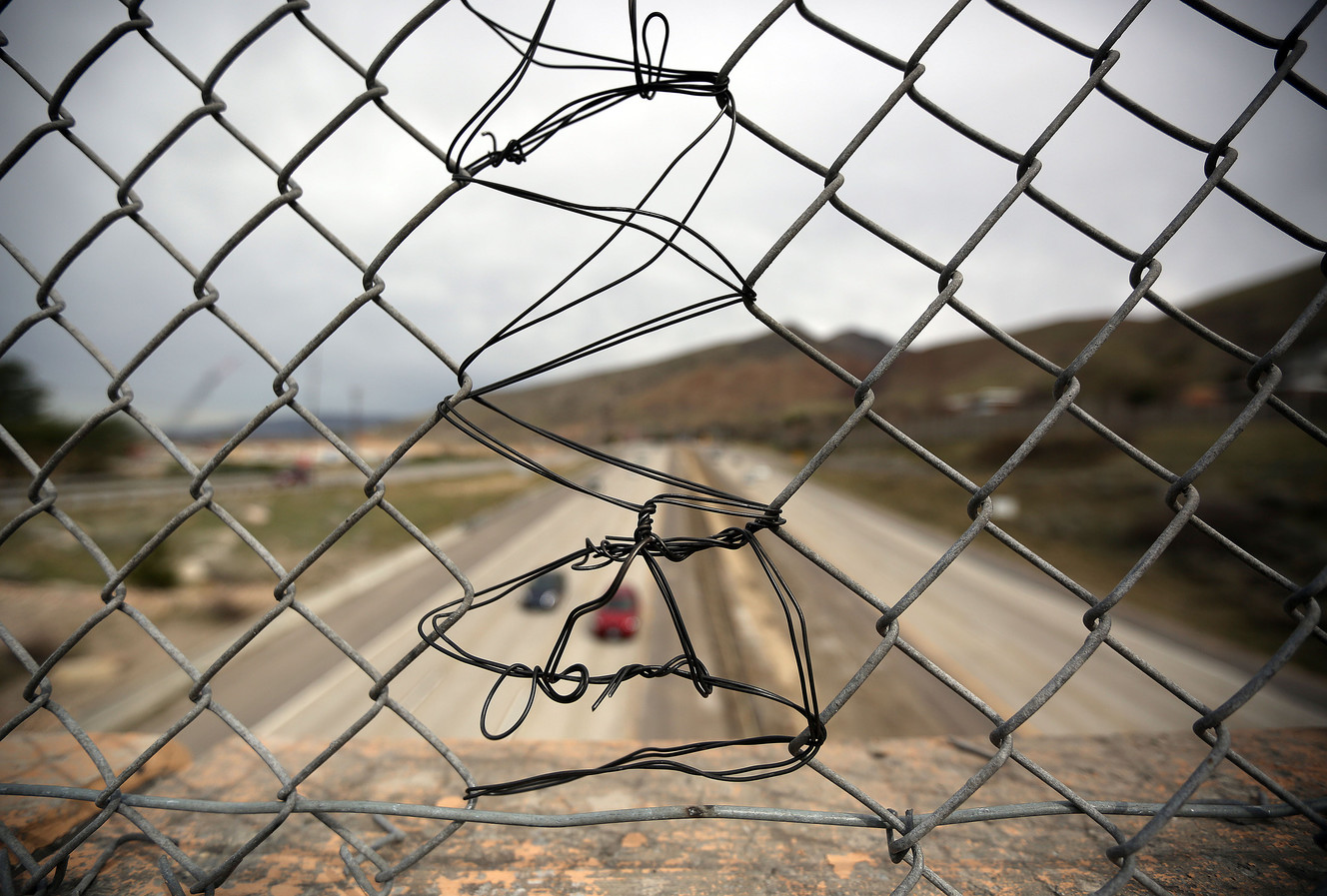 Utah Highway Patrol troopers had to cut a hole in the chain-link fence on the 3300 South overpass spanning I-215 in Millcreek to prevent a woman from jumping on Tuesday, March 21, 2017. The hole was quickly patched. (Photo: Kristin Murphy, Deseret News)