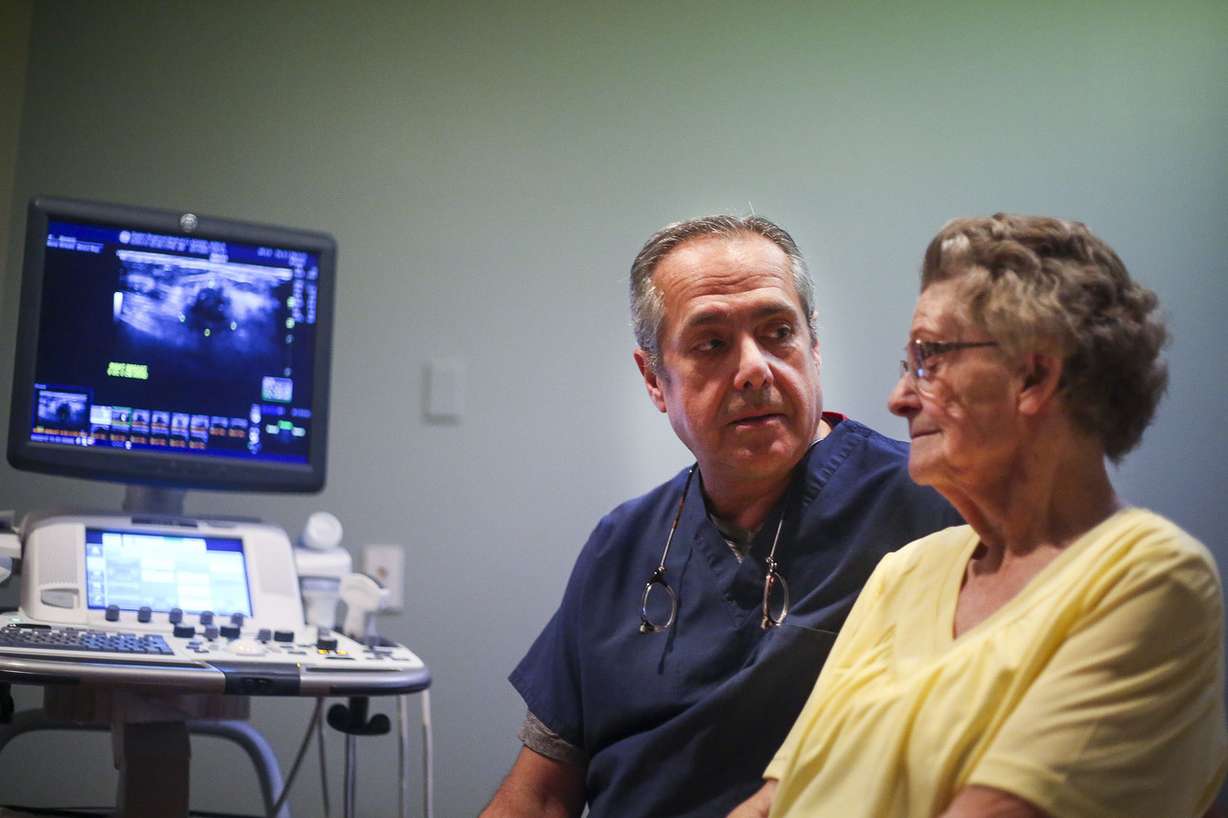 Dr. Jose Perez-Tamayo, left, sits with patient Adele Adams, 92, right, at Ogden Regional Medical Center in Ogden on Wednesday, March 22, 2017. Photo: Nicole Boliaux, Deseret News