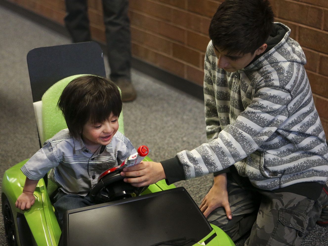 Ricky Beard, 14, left, tries to calm down his brother, Braxton, 2, as he tests out his new adapted electric car at the Utah Center for Assistive Technology in Salt Lake City on Thursday, March 23, 2017. Photo: Nicole Boliaux, Deseret News