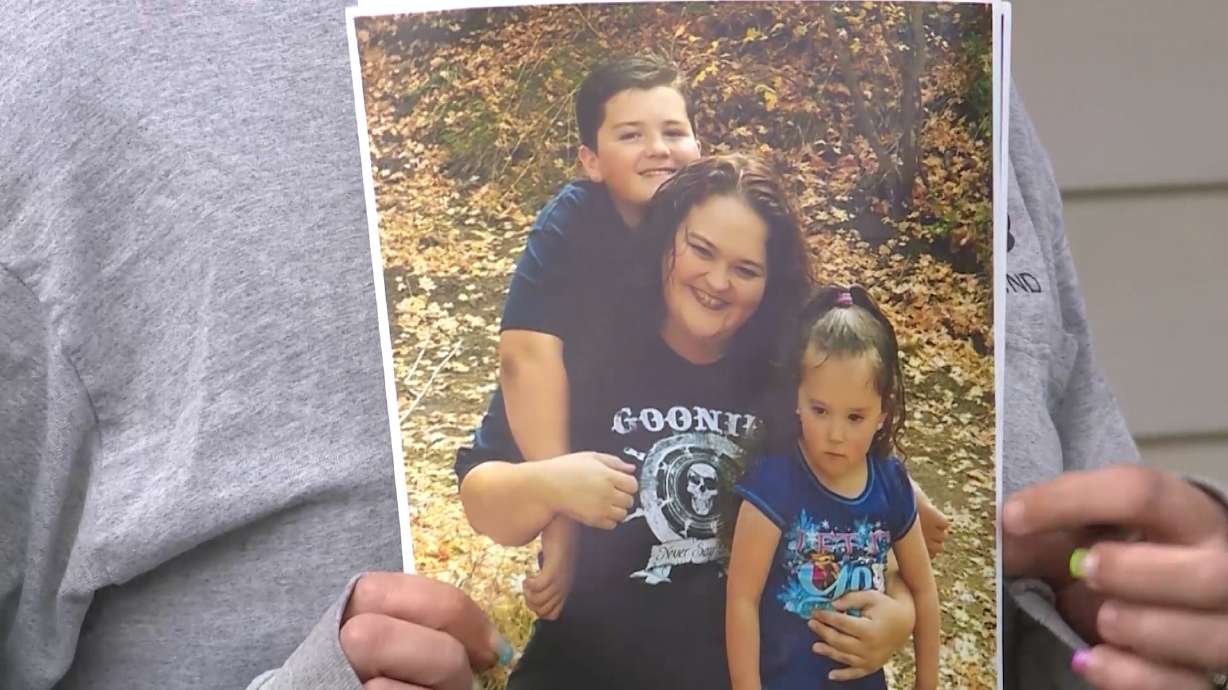 A family member holds up a picture of Kammy Edmunds and her children. The 34-year-old woman was found dead in her Mt. Pleasant home on March 31, 2017. Her fiancé, Anthony Christensen, was convicted of murder.