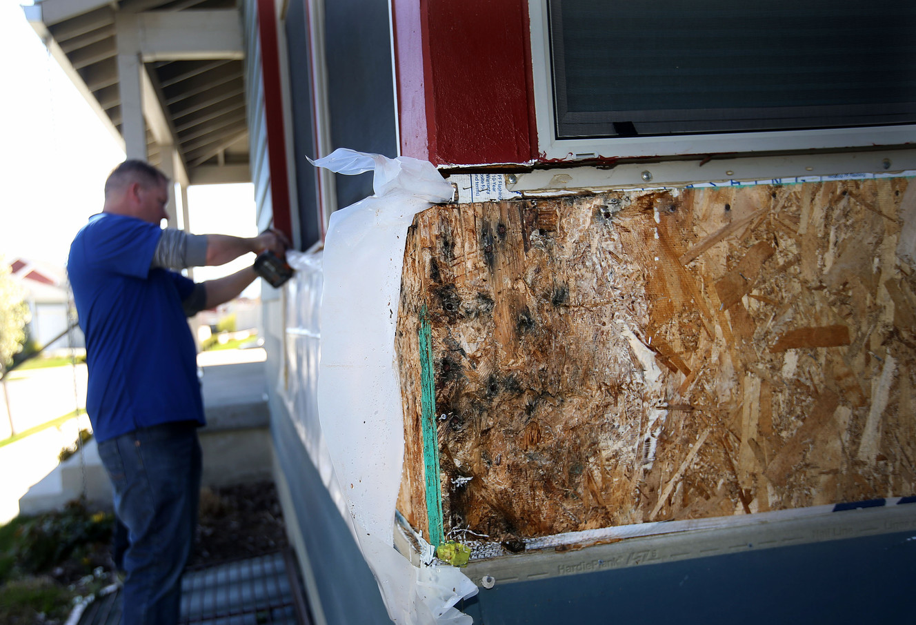 David McKeeth of Gores Construction removes plastic from the rotting facade of a town house during the Daybreak Townhome 1 Homeowners’ Association press conference at Daybreak in South Jordan on Wednesday, April 12, 2017. The Townhome 1 Homeowners’ community is made up of nearly 400 families, all living in town houses suffering from severe construction defects and from water damage inside the walls. The dispute over whether the builders and developer will pay the millions needed to repair the damage is being litigated in 3rd District Court in Salt Lake City. (Photo: Laura Seitz, Deseret news)