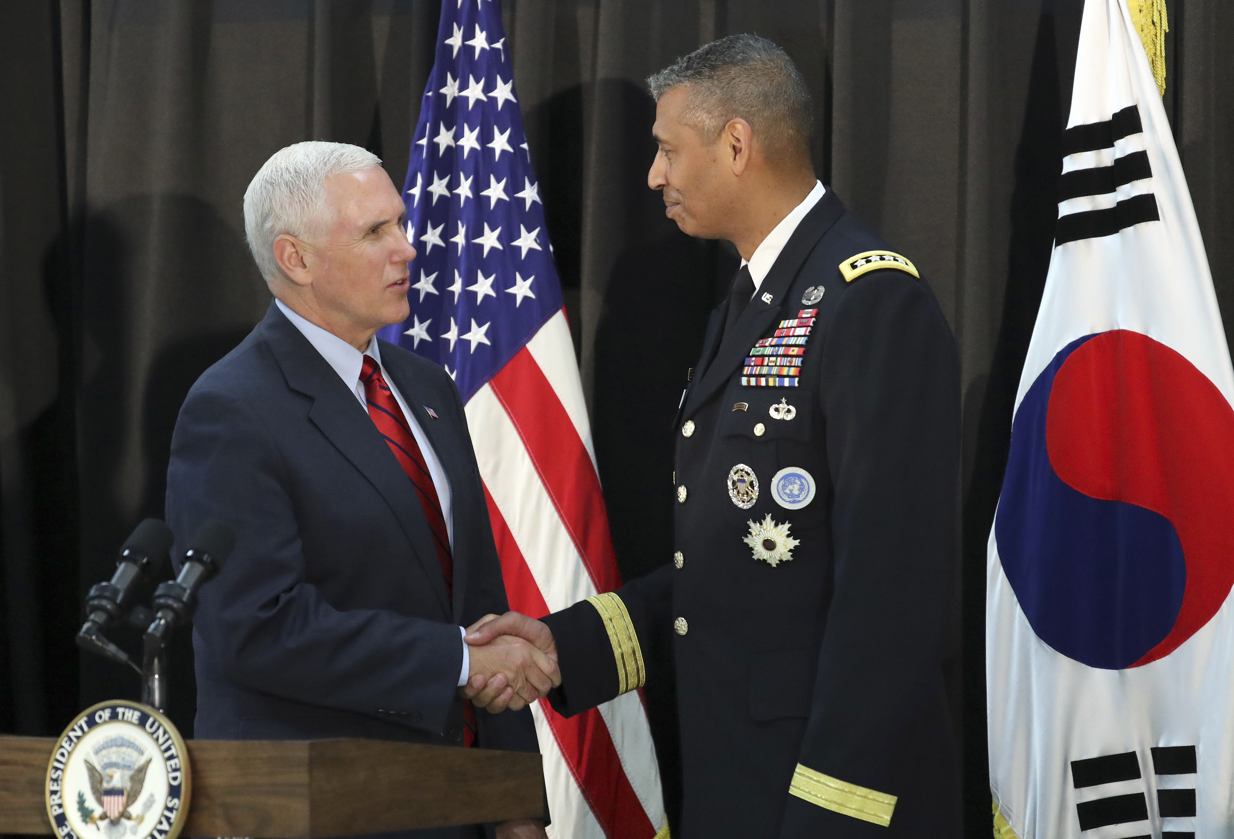 U.S. Vice President Mike Pence, left, shakes hands with U.S. Gen. Vincent Brooks, commander of the United Nations Command, US Forces Korea and Combined Forces Command before a dinner with soldiers and family members after Easter Sunday church services at a military base in Seoul, South Korea, Sunday, April 16, 2017. Pence said Sunday that North Korea's "provocation" underscored the risks faced by American and South Korean service members, hours after the North conducted a failed missile launch shortly before Pence's arrival. (Lee Jin-man, Associated Press)